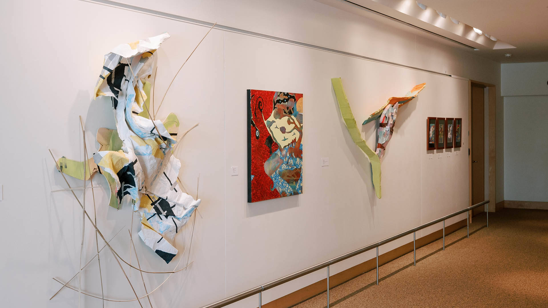 Several sculptures and paintings hanging on a wall.