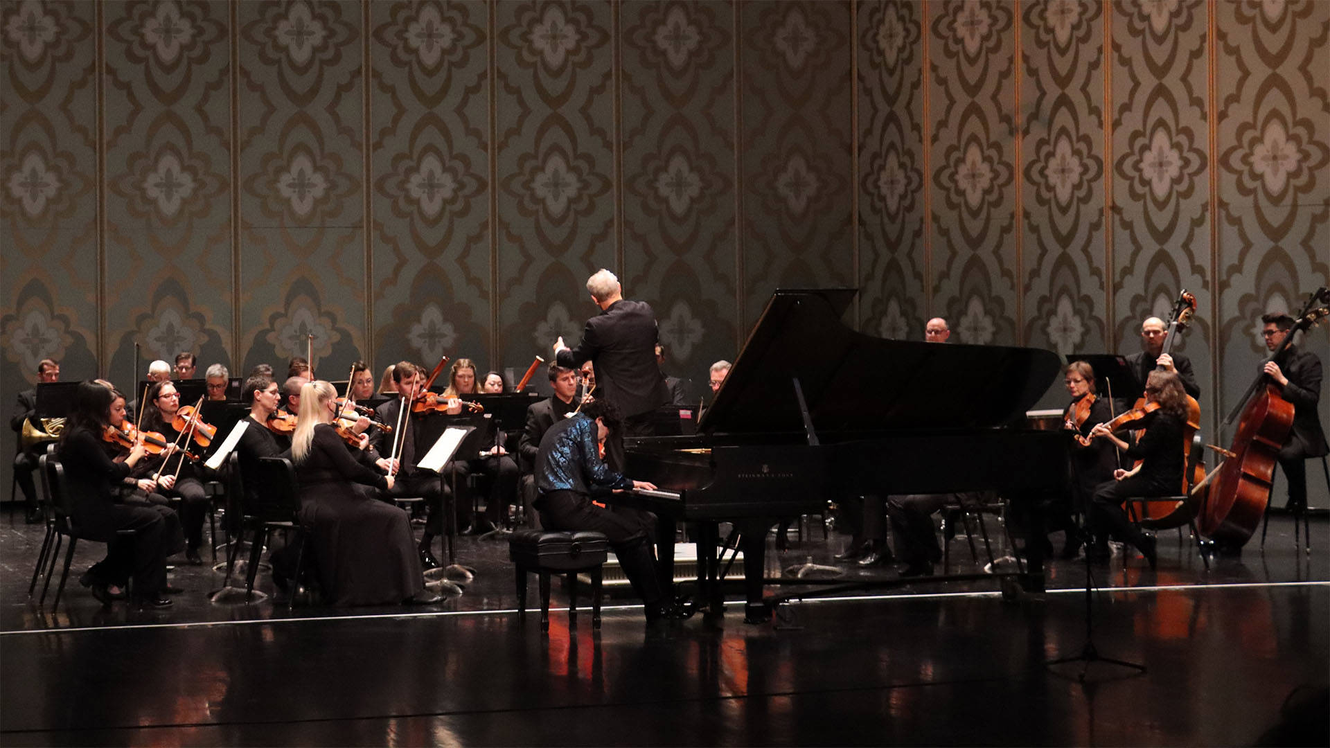 Wisconsin Chamber Orchestra performing on Capitol Theater stage with a grand piano and conductor.
