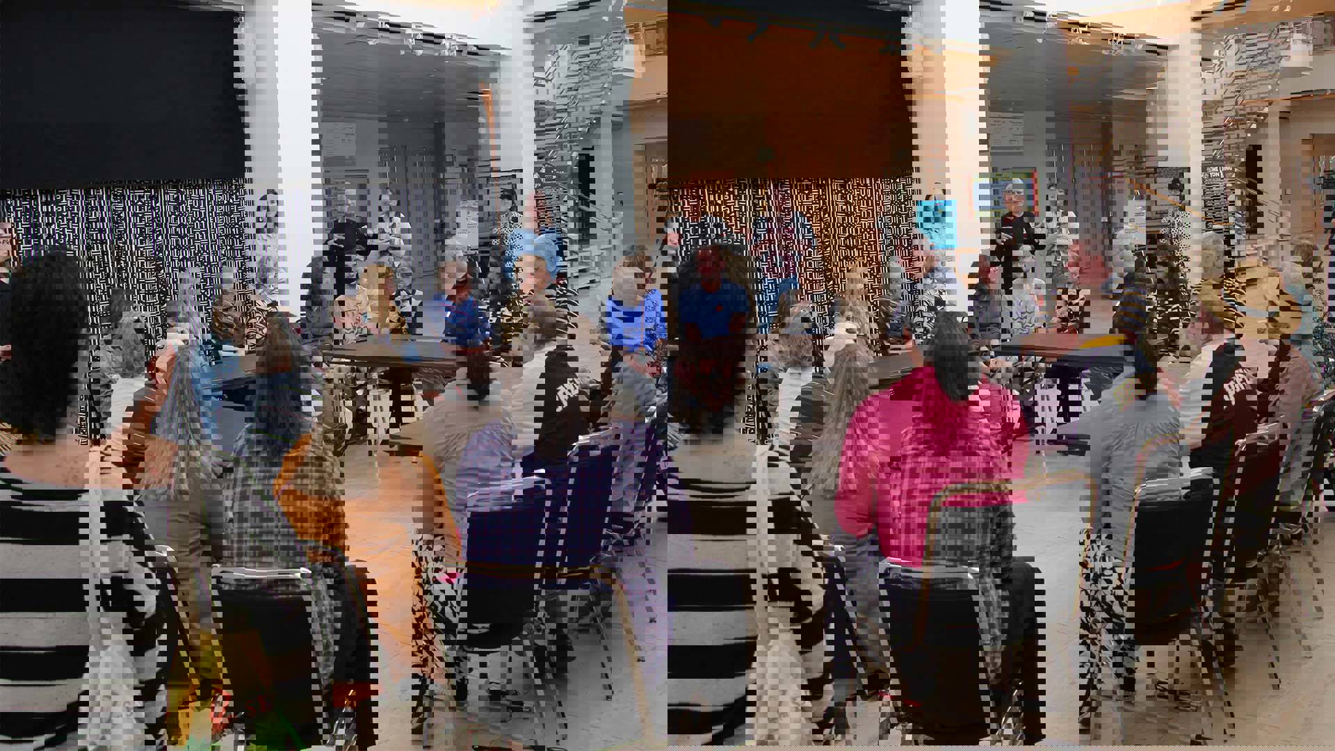 A group of people sitting in a circle in Overture Hall lobby.