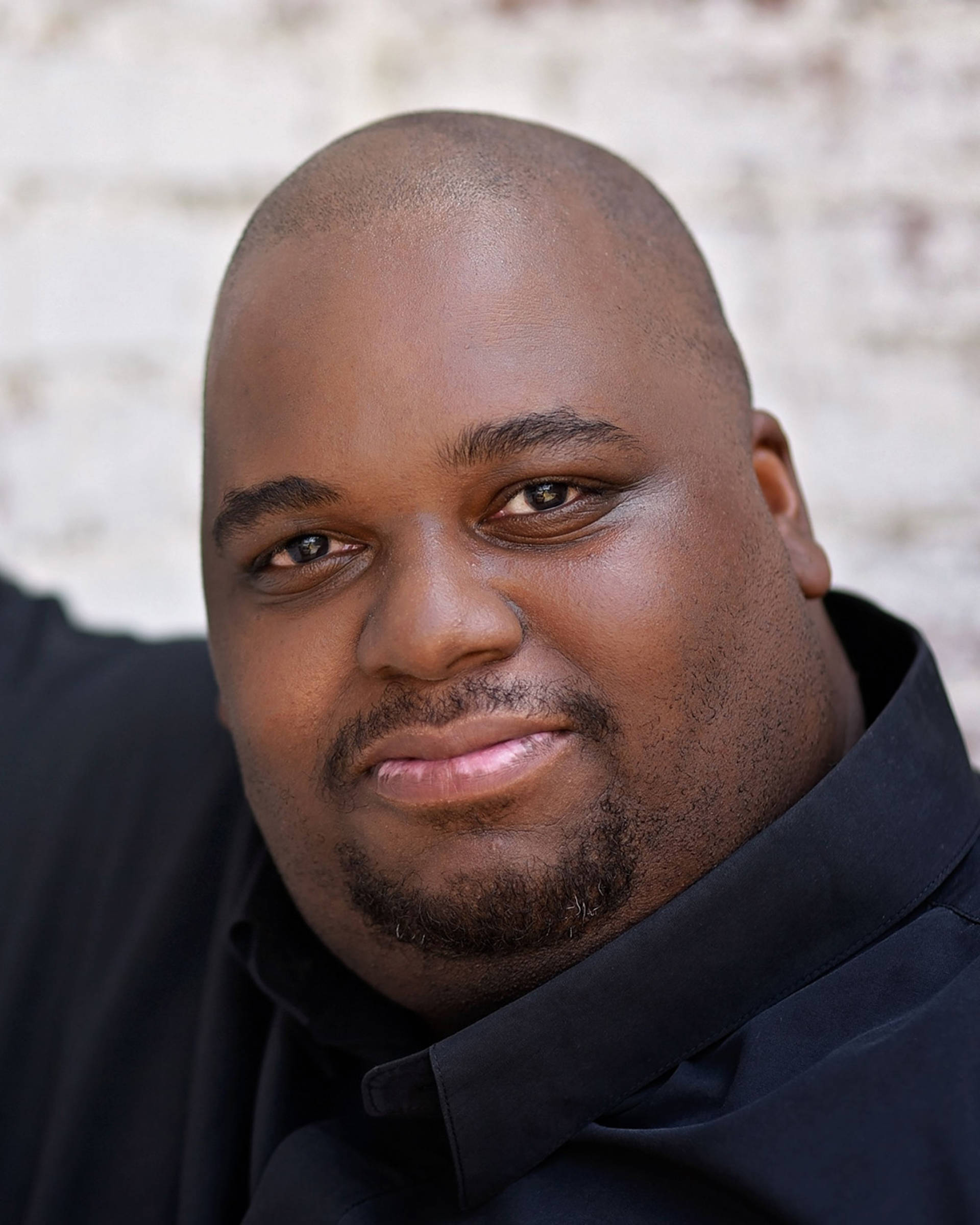 Headshot of an African American man with a bald head, brown eyes and a goatee.