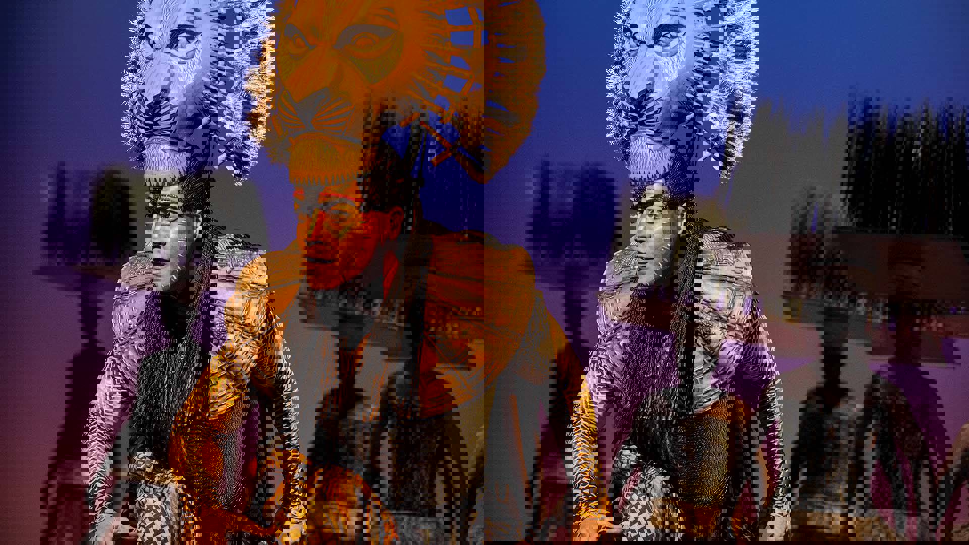 An actor dresses as Mufasa leans forward.