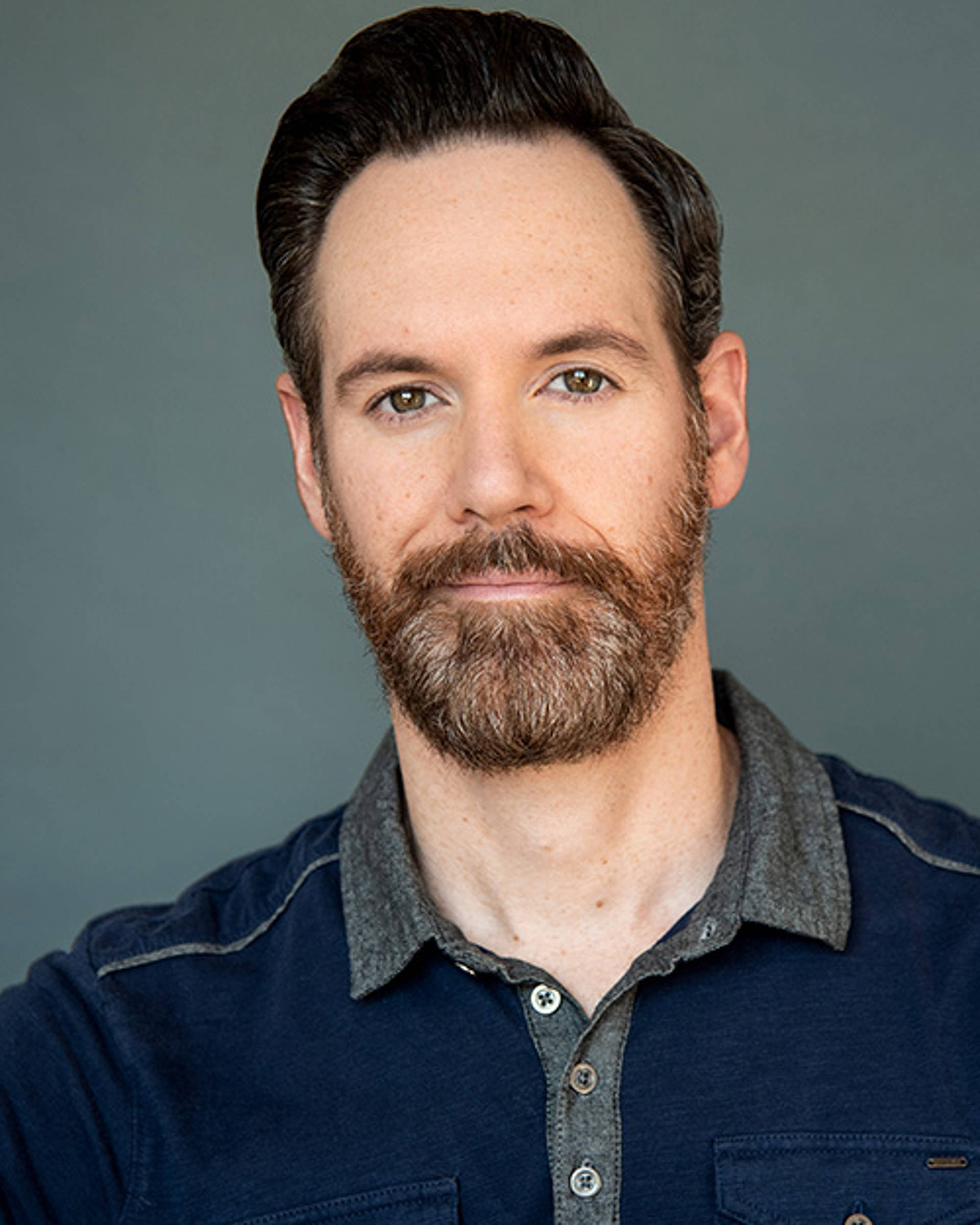 Headshot of a white man with a grey and brown beard and hazel eyes.