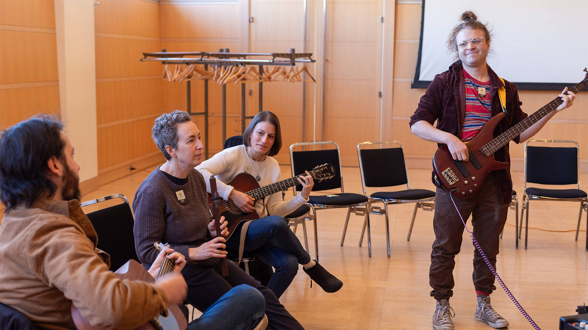 Four adults playing string instruments and a recorder.