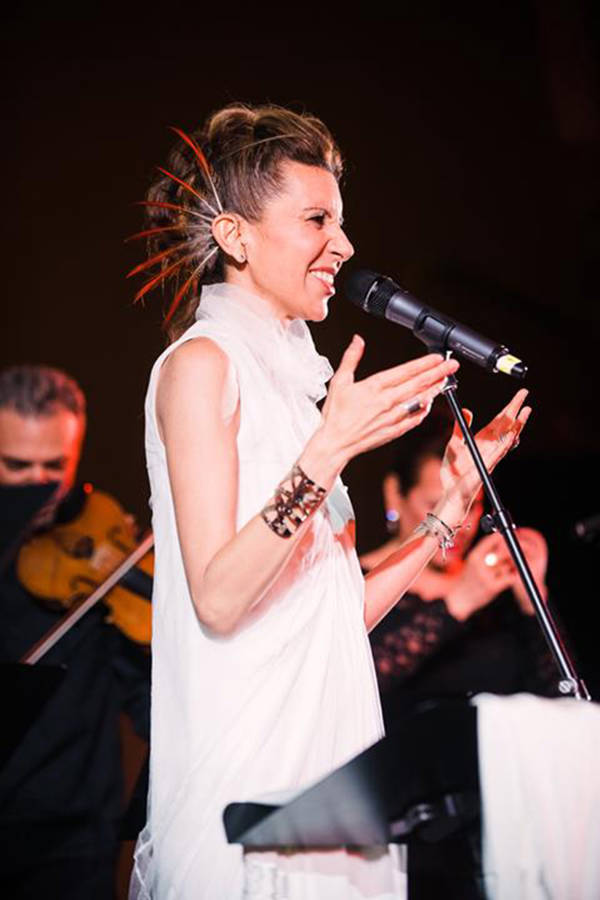 Magos Herrera, a Mexican woman with light brown long hair performing on stage.