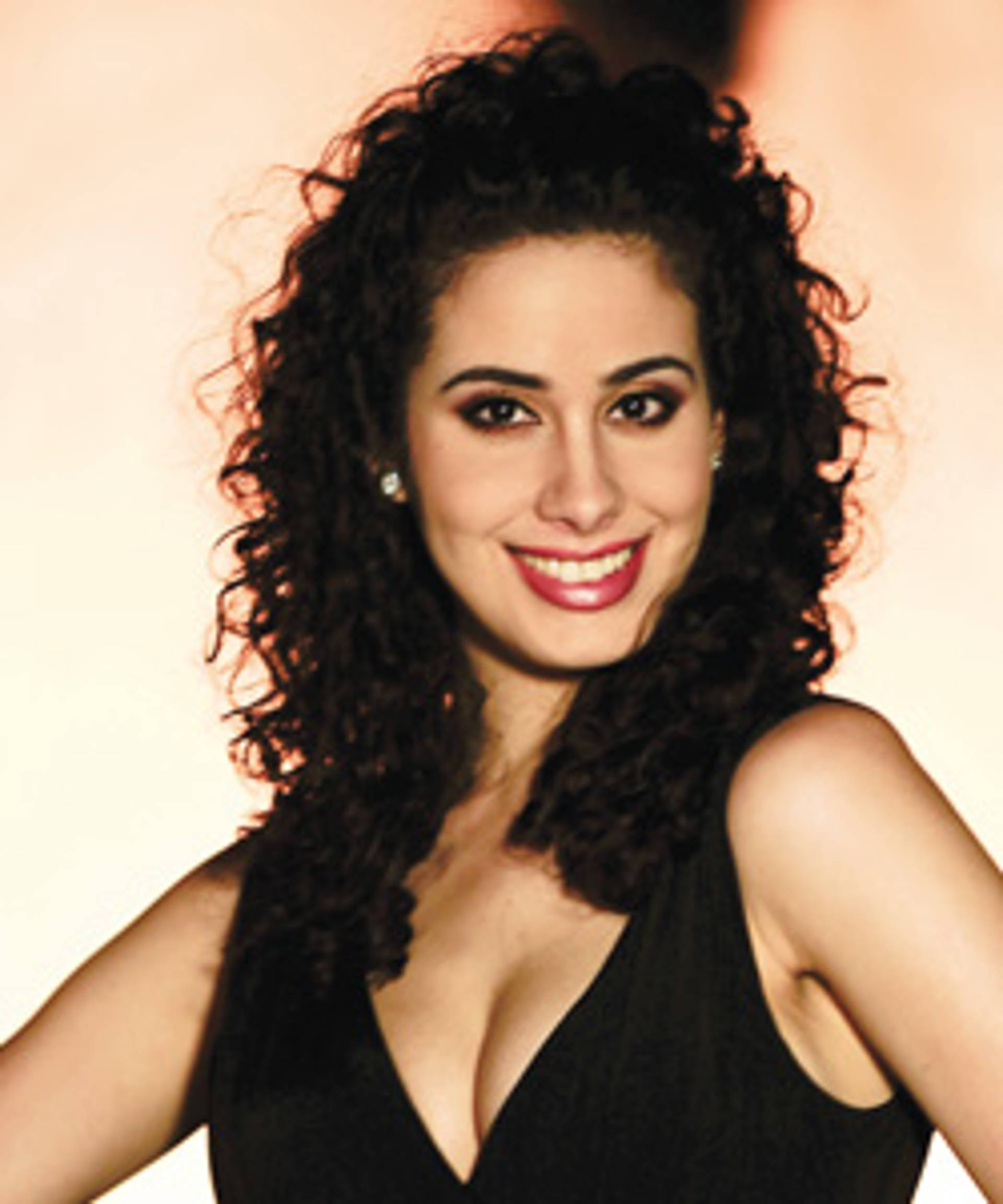 A young woman with light skins and long wavy dark hair.