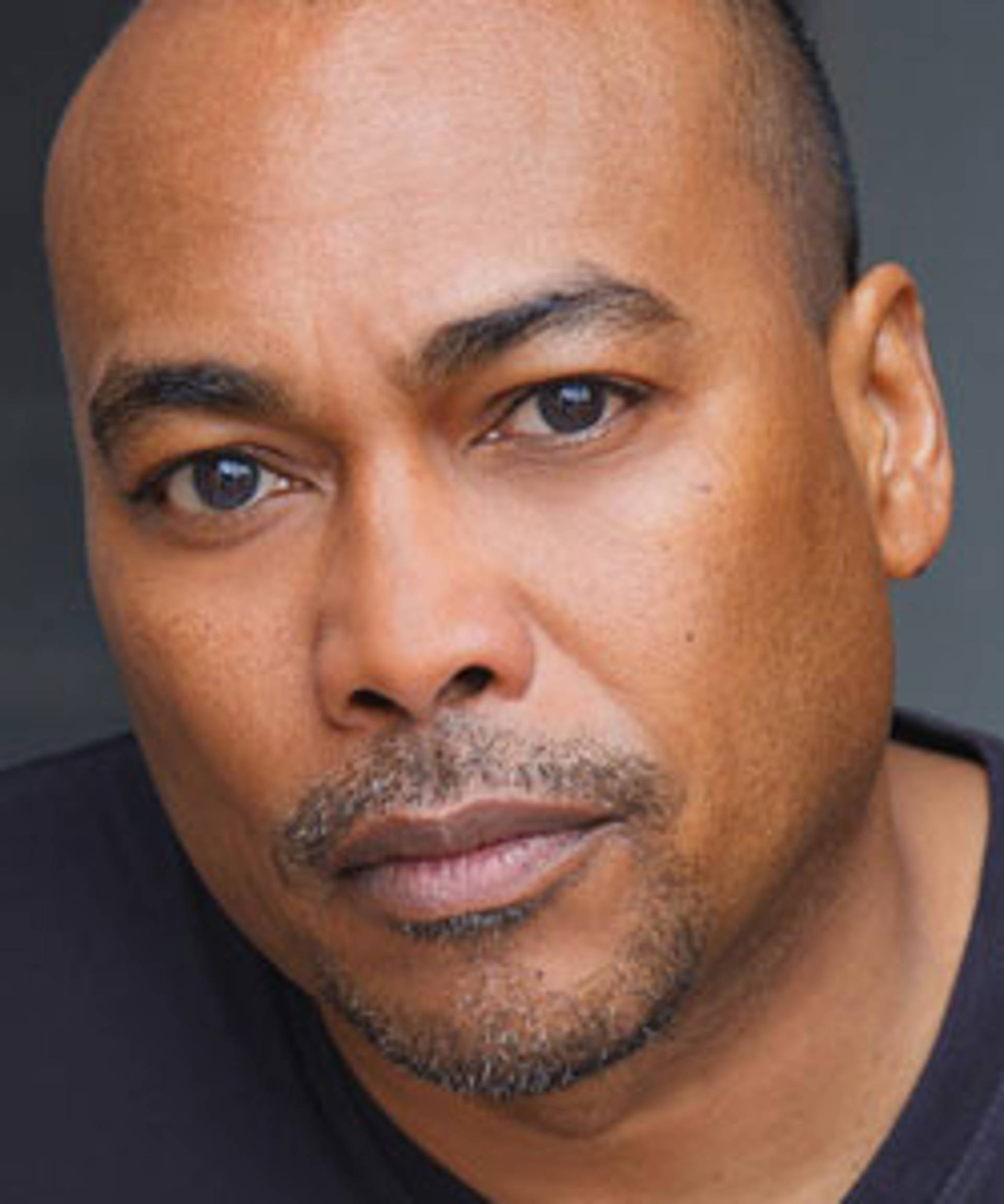 Headshot of an African-American man with brown eyes and a short goatee.