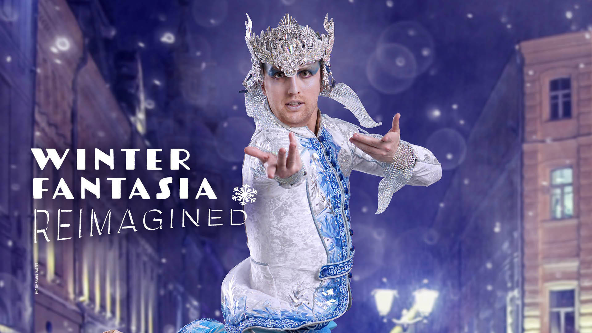 Banner reads: "Winter Fantasia Reimagined." A caucasian dancer in an ornate winter-ice themed white & blue costume and headpiece poses in a snowy night street scene.