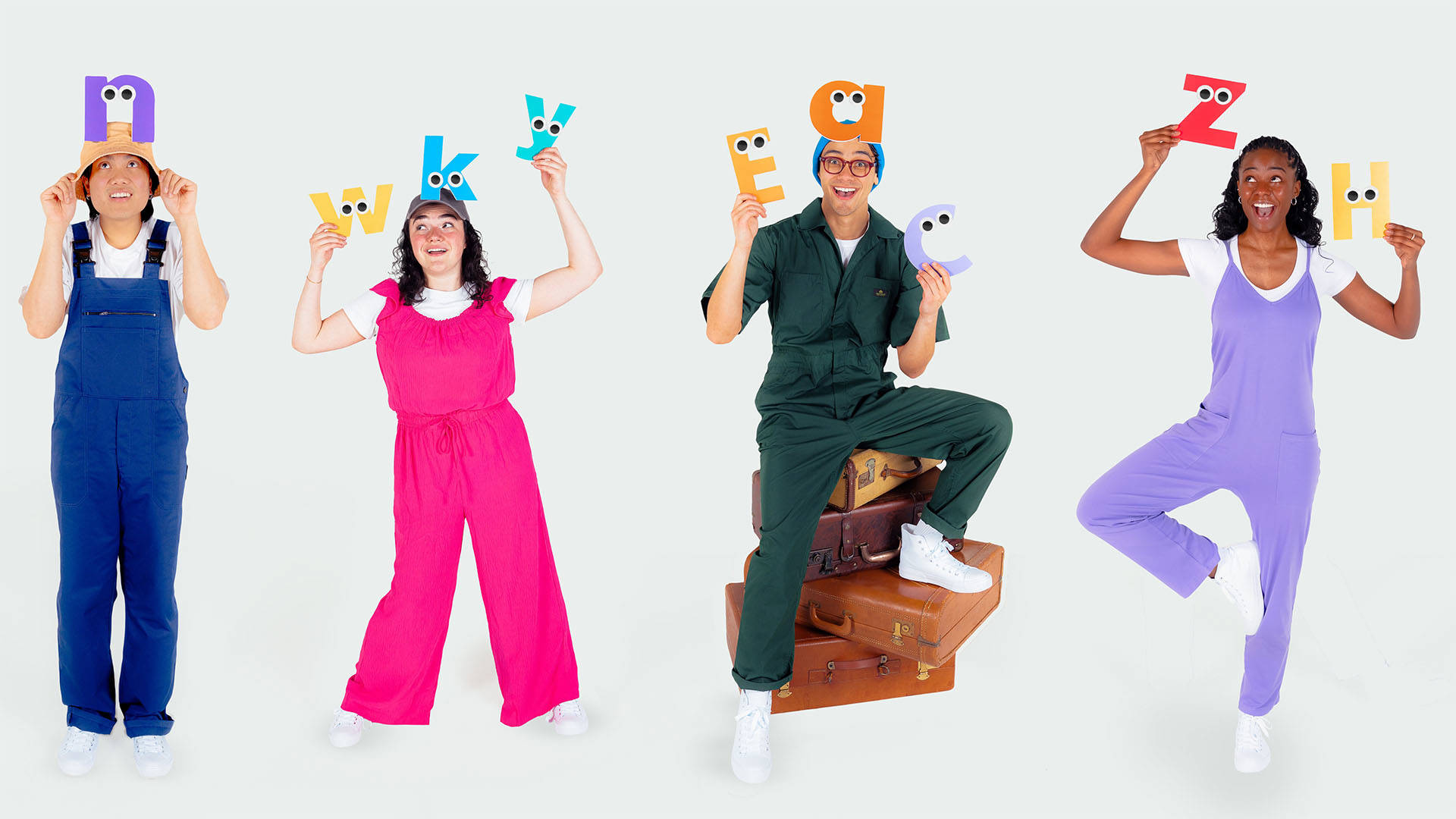 Four people in playful colorful outfits againsts a white background. They are each holding colorful letters of the alphabet, each with a pair of eyes on them.