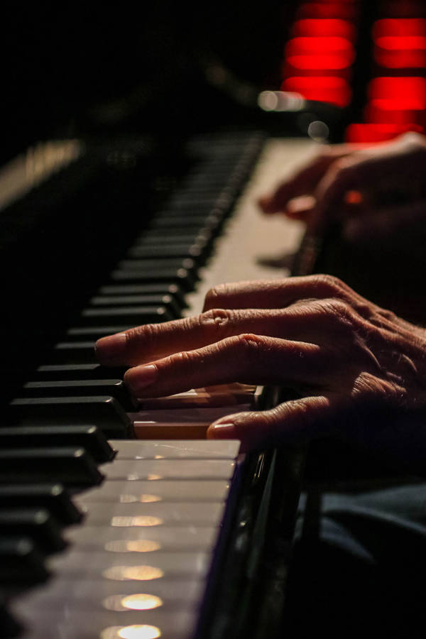 George Winston's hands playing a piano.