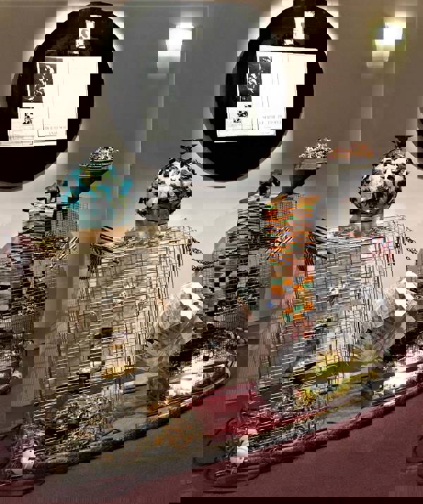 A complex artistic sculpture with wire, paper, and metal materials in a gallery