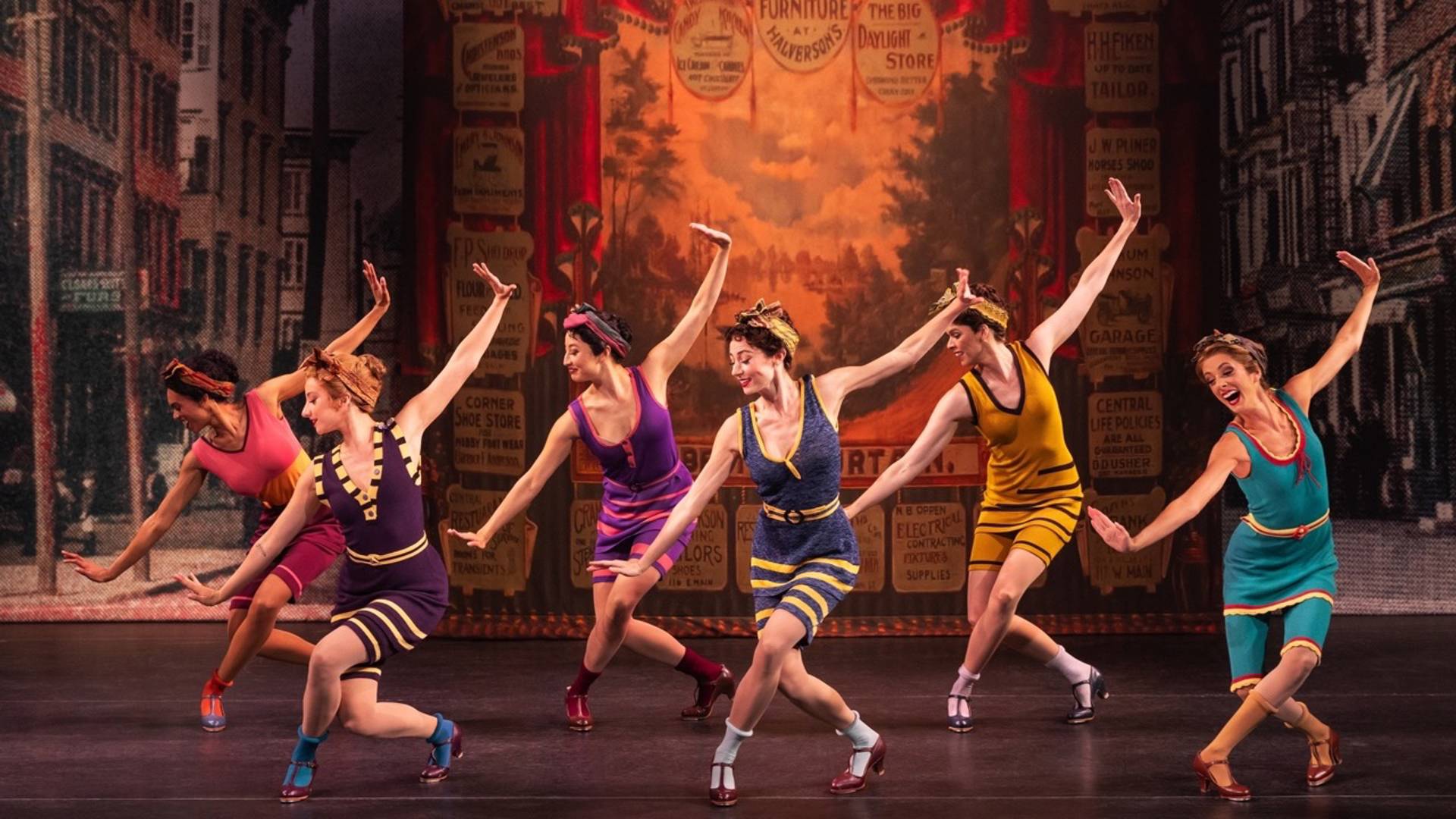 An ensemble of women dancing in various colorful 1920's-era swimsuits.