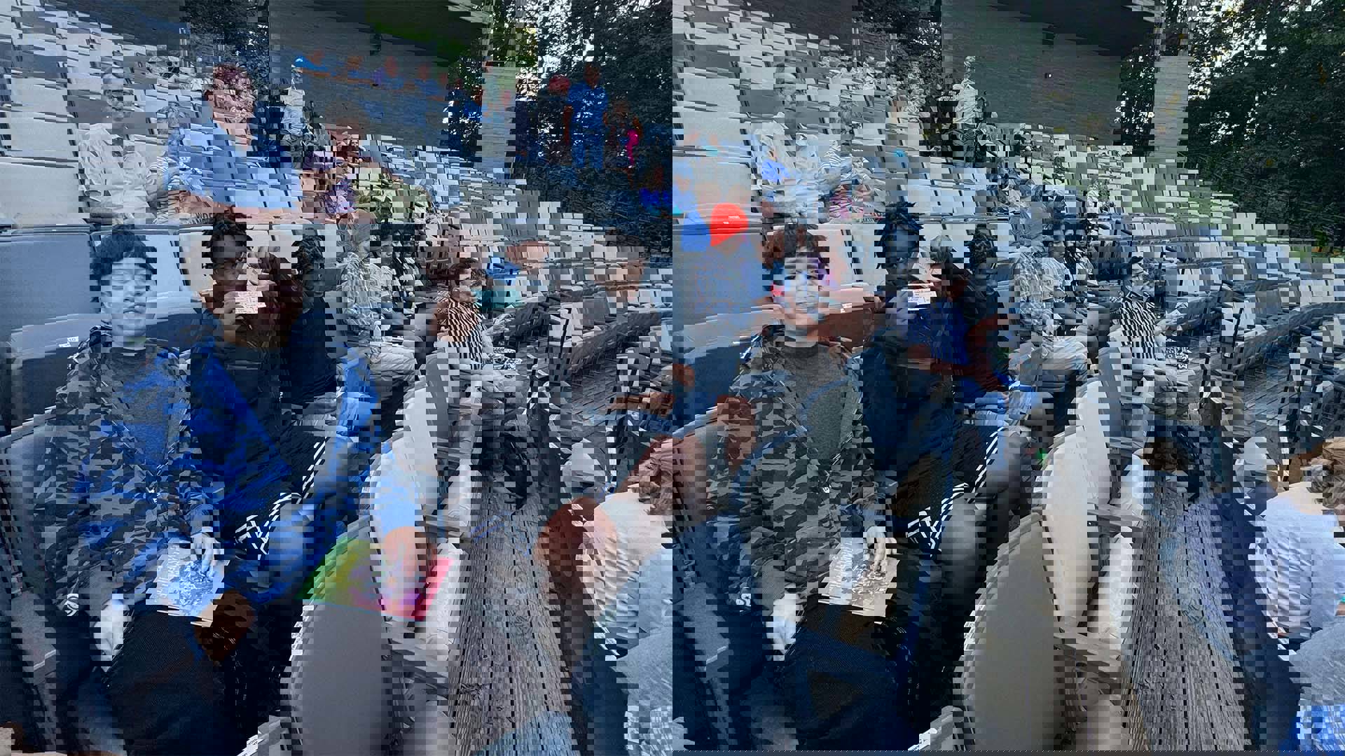 Students sitting in an outdoor theater with blue and cream colored seating.