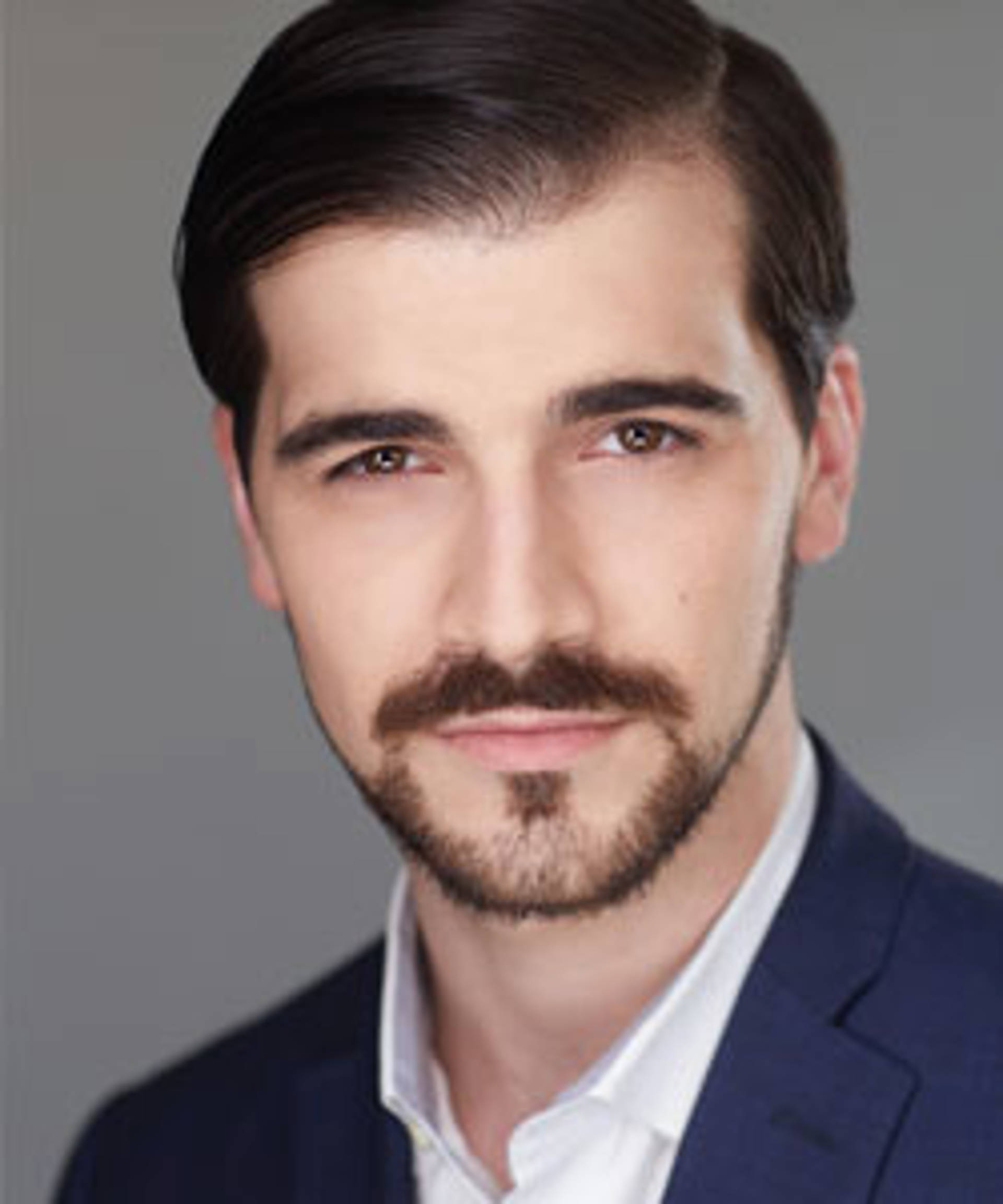 Headshot of a caucasian man with dark eyes, a short beard and short brown hair