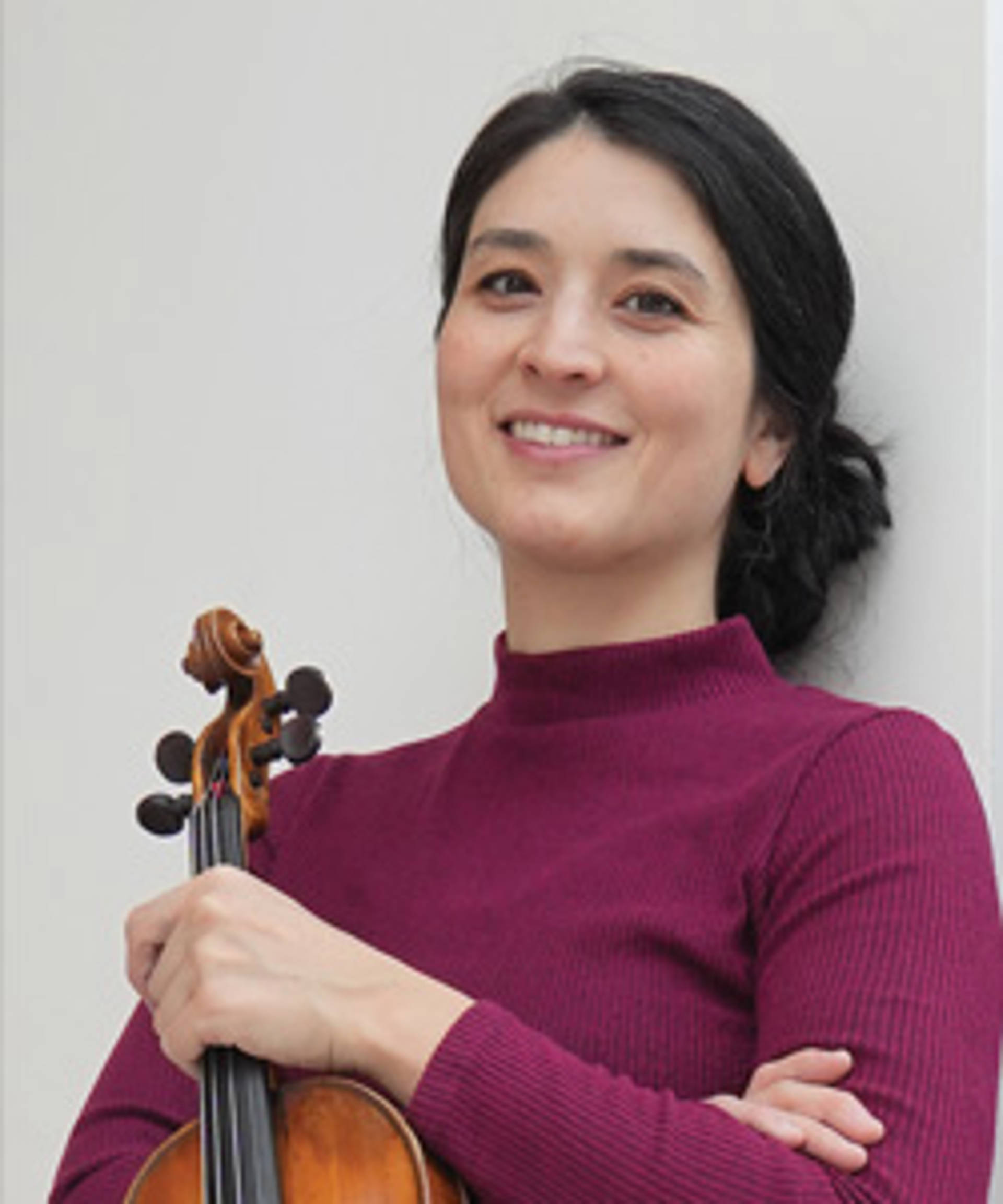 A young woman with tight skin, dark long hair and a purple top holding a violin