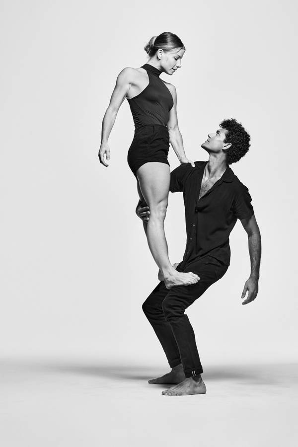 Greyscael image of two dancers in black outfits.