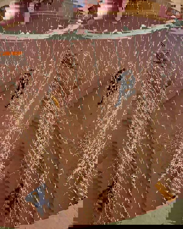 Overture tech staff suspending a halo of lights in Rotunda Lobby