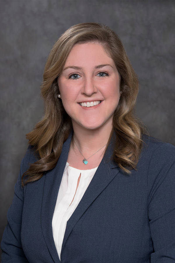Headshot of a smiling caucasian woman with long dark blonde hair with blue eyes.