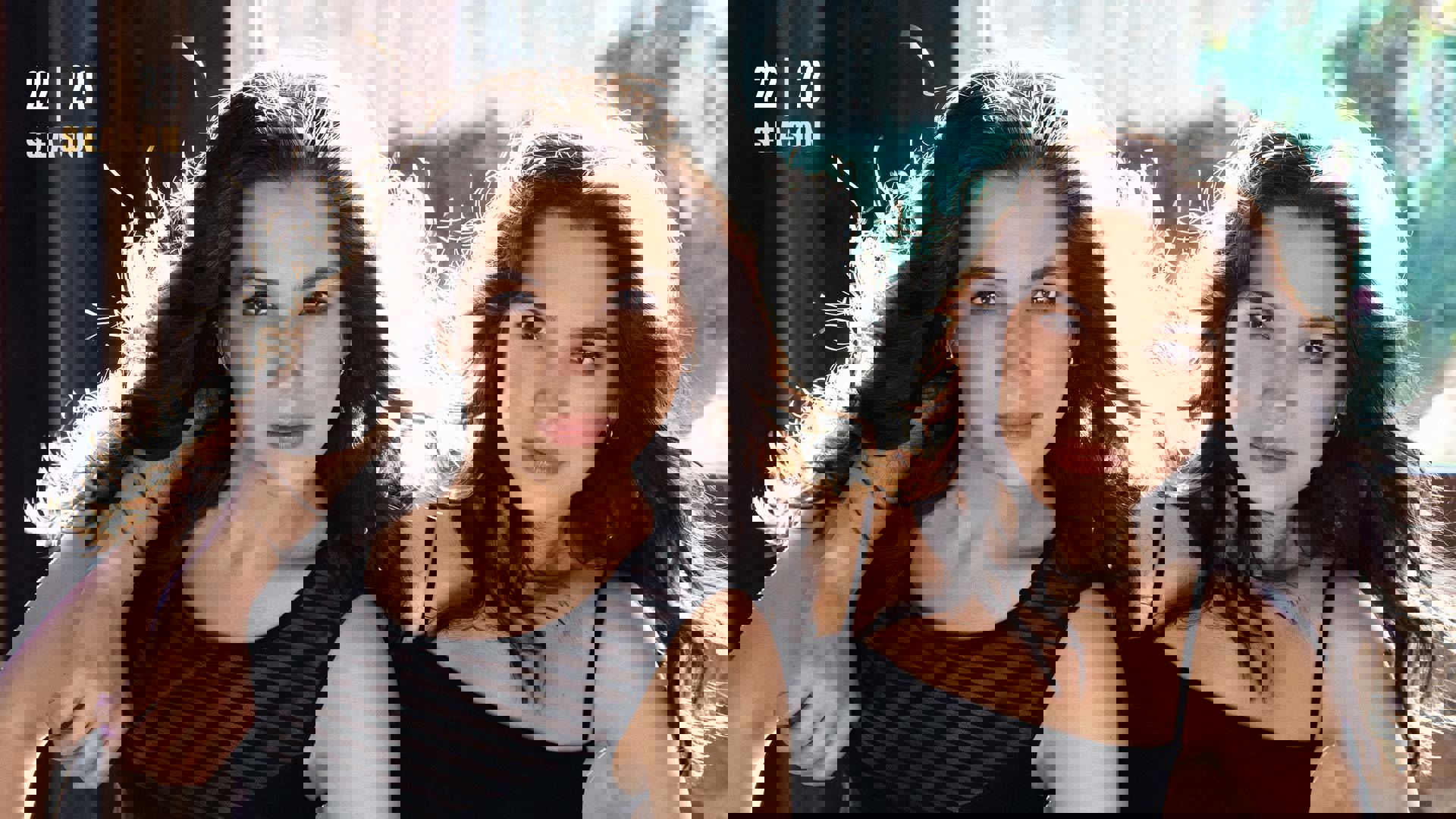 Banner text reads: 22 | 23 season. Two sisters hold each other and star intently into the camera. They both have brown eyes and long brown hair. They are wearing black tops.