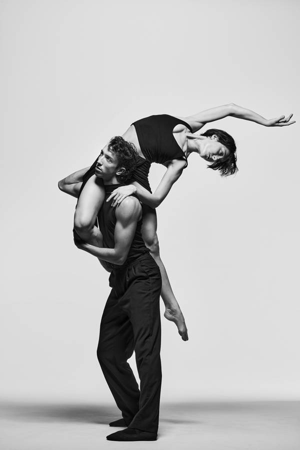 Greyscael image of two dancers in black outfits.