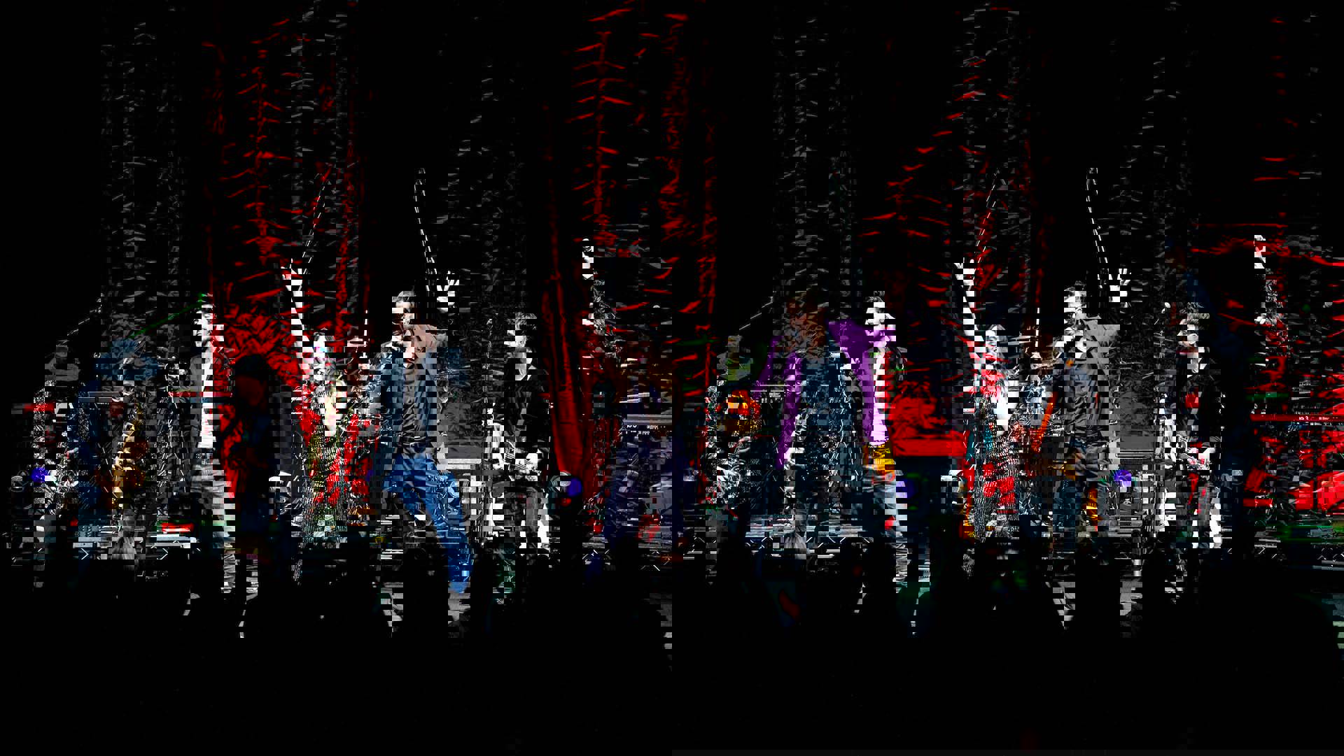 A band performing on a stage in front of a dancing crowd.