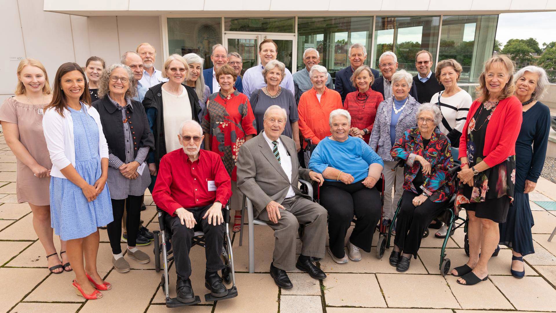 A group of people standing together for a photo on rooftop.