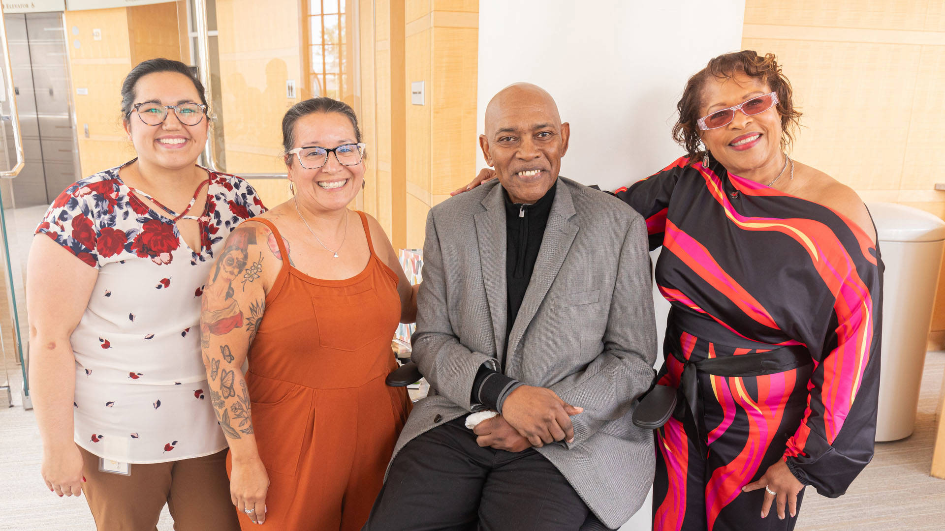 Four people pose for a photo together smiling.