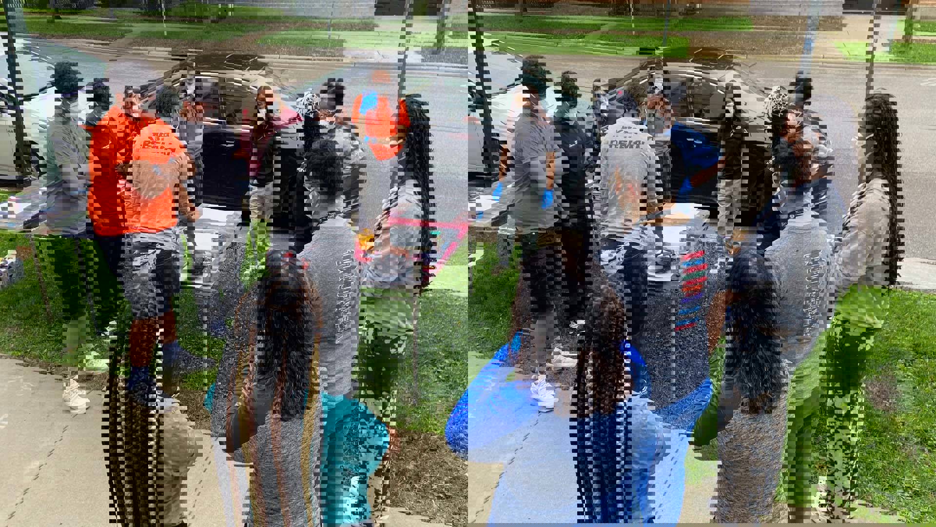 Students outside on a sidewalk creating art with spraypaint.