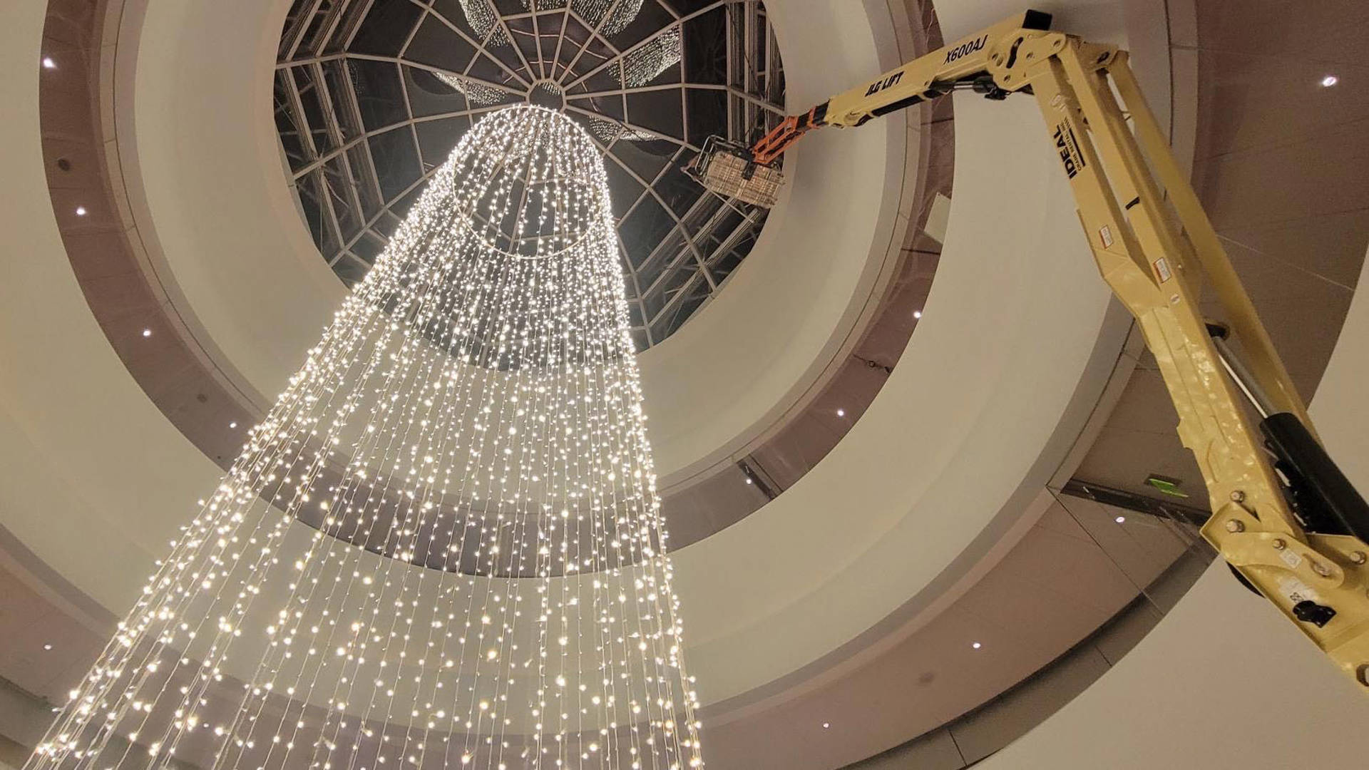 Overture tech staff suspending a halo of lights in Rotunda Lobby