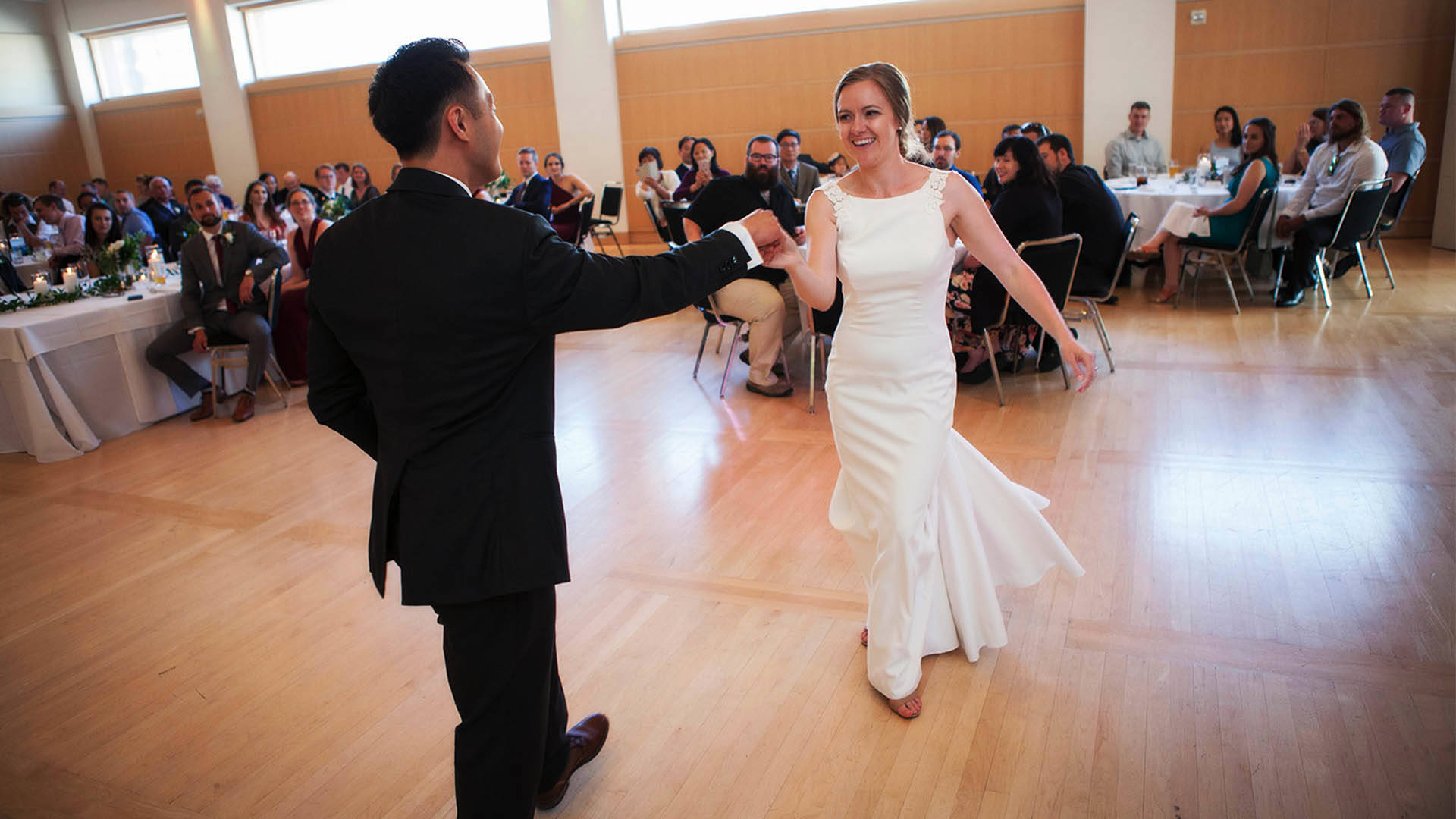 A bride and groom dancing in front of guests. 