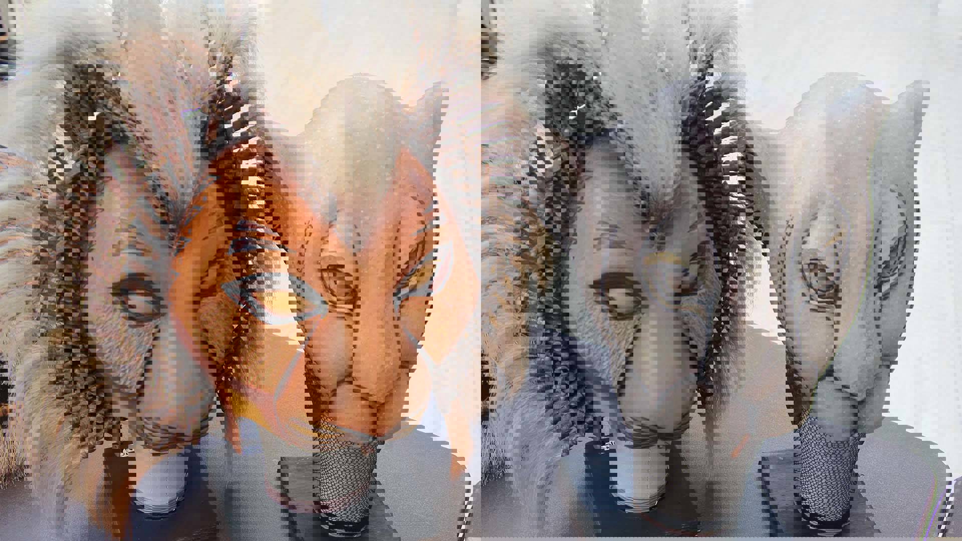 Two wooden lion masks sitting on a table.