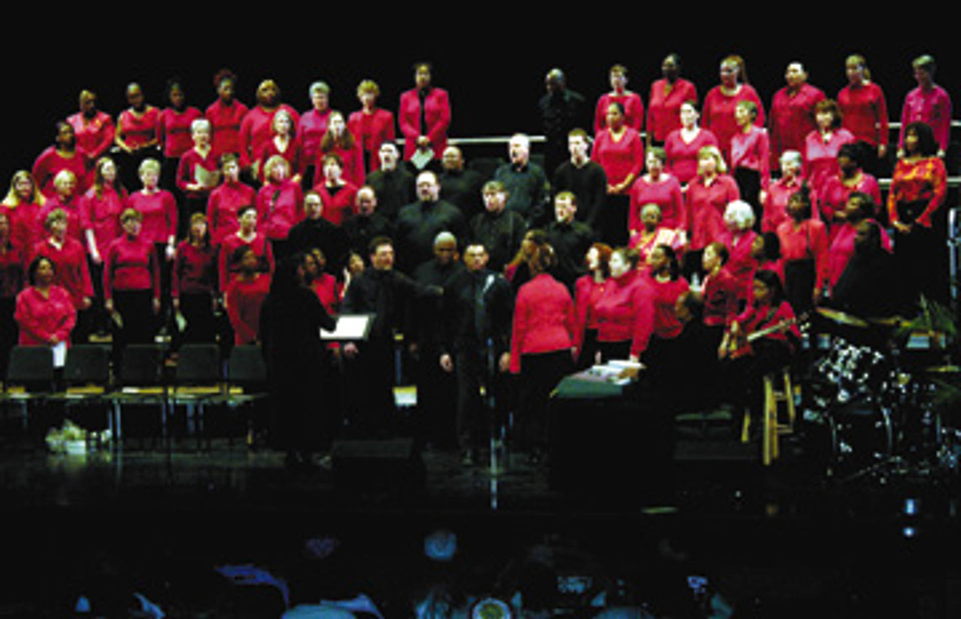 A choir in red and black outfits performing