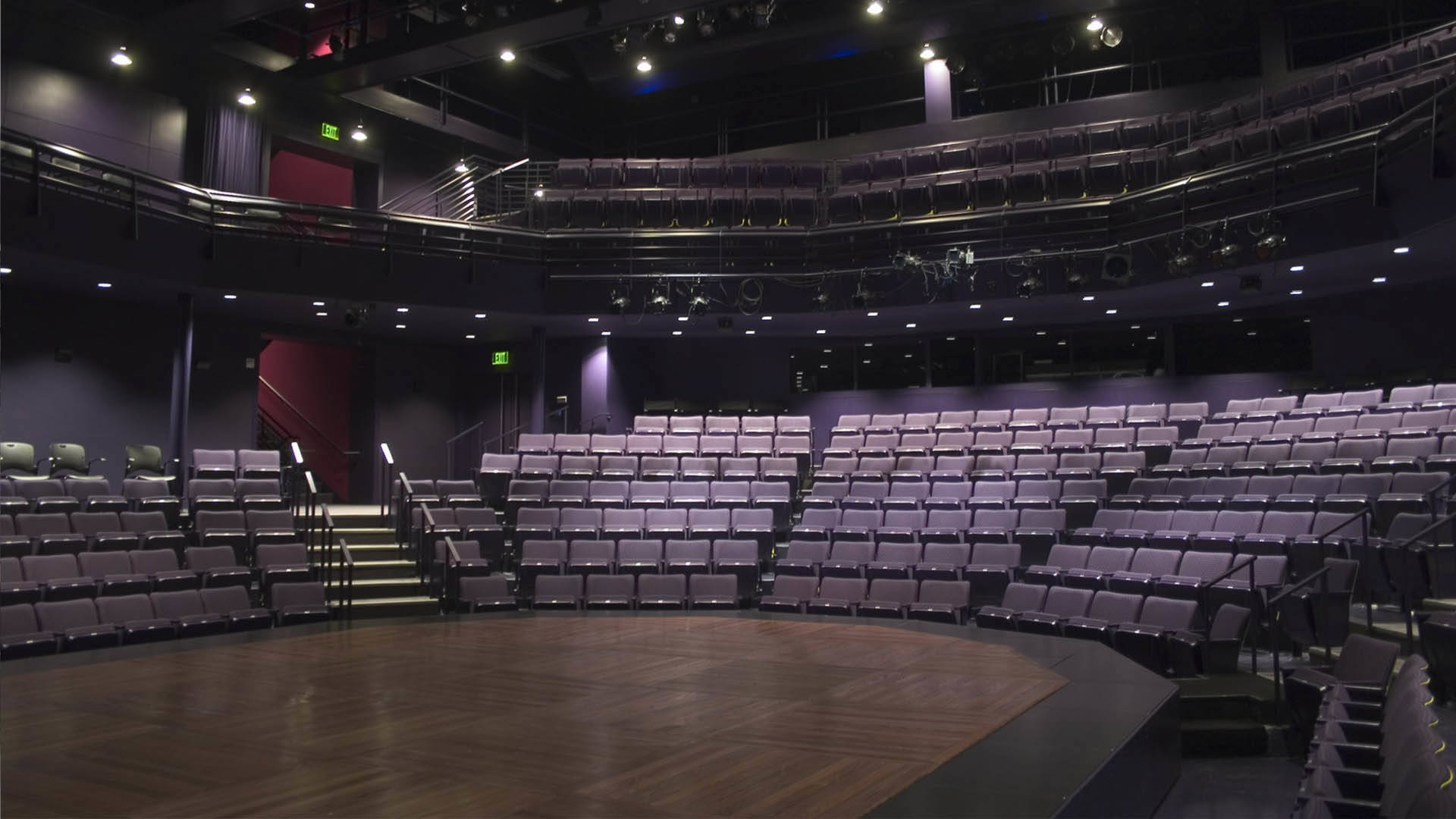 A view from the Playhouse stage. It is a thrust stage with two levels of purple seating.