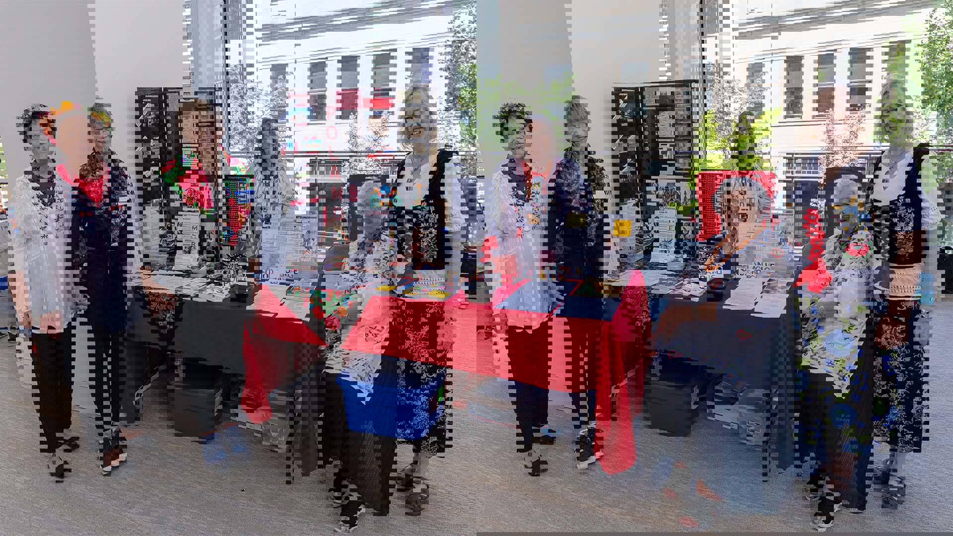 Five women gathered around a display booth