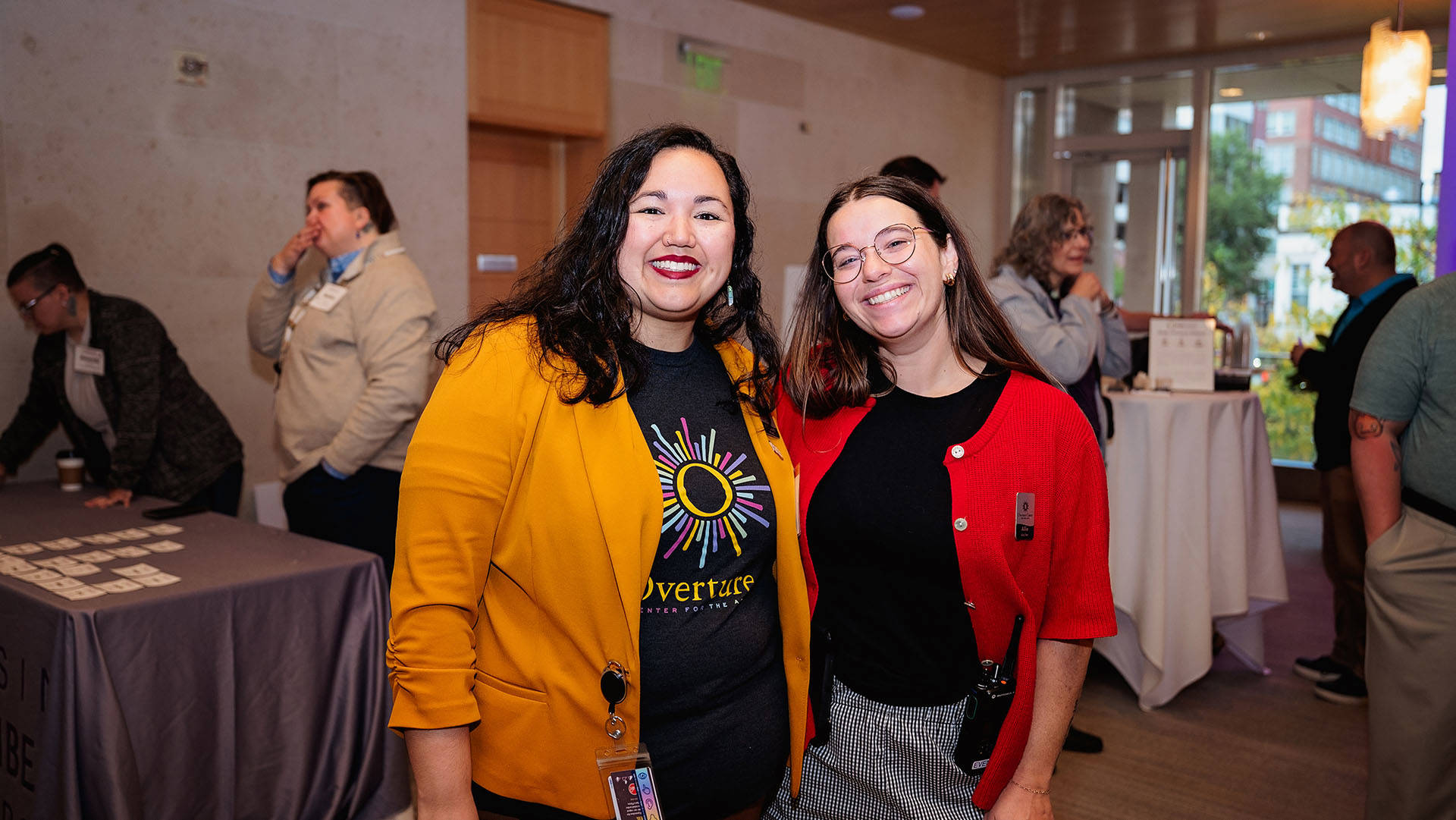Two women with long, brown hair smile for the camera.