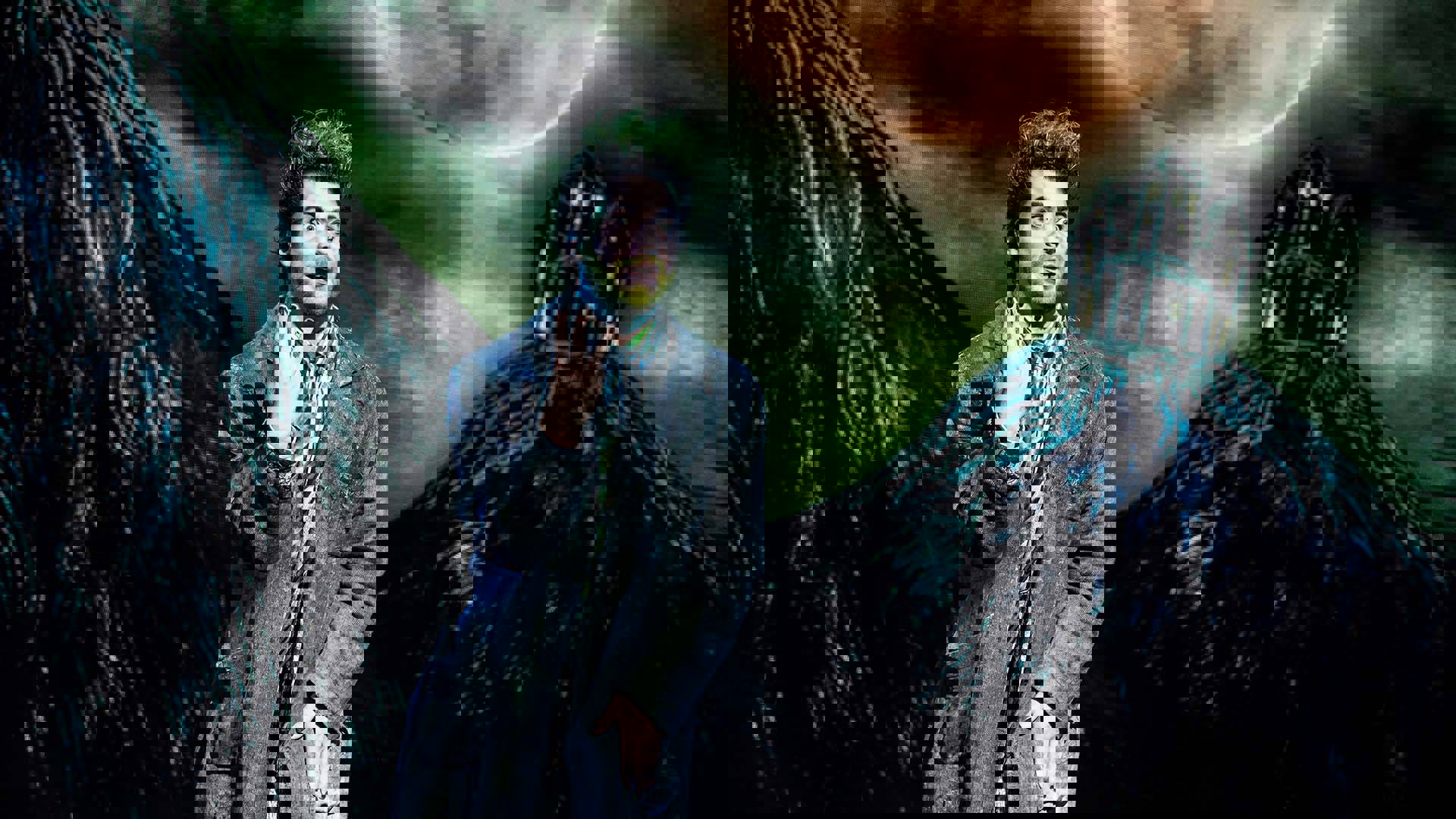 Beetlejuice performing on stage. He has ghostly pale skin with green and black hair. He is wearing a grey long-coat and is holding up three fingers.