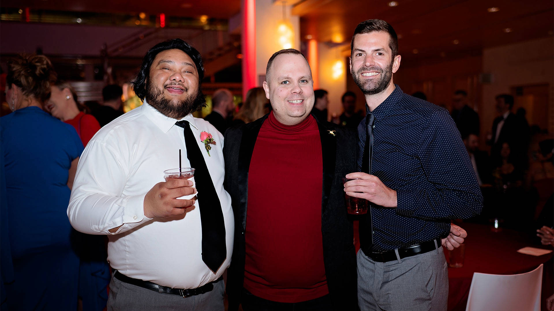 Three people stand together for a photo.