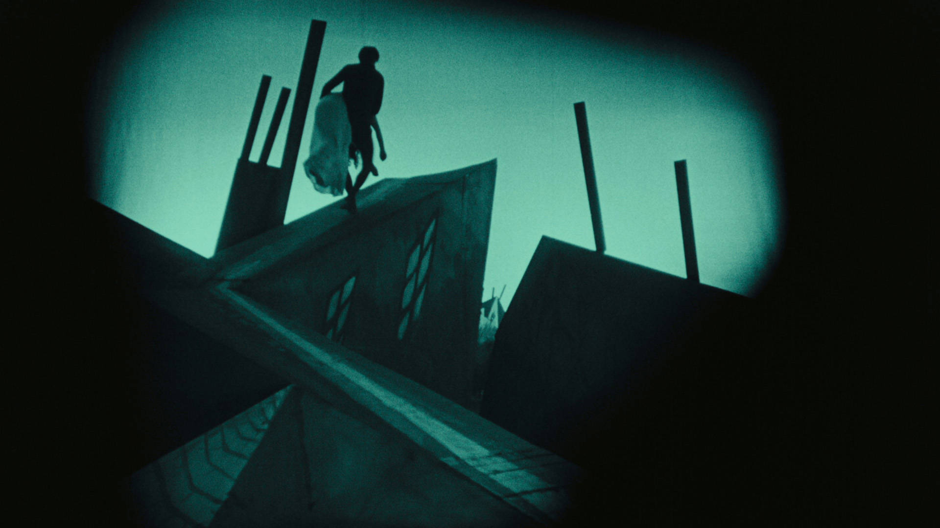 Surreal green tinted image of rooftops and a figure carrying a woman's body.