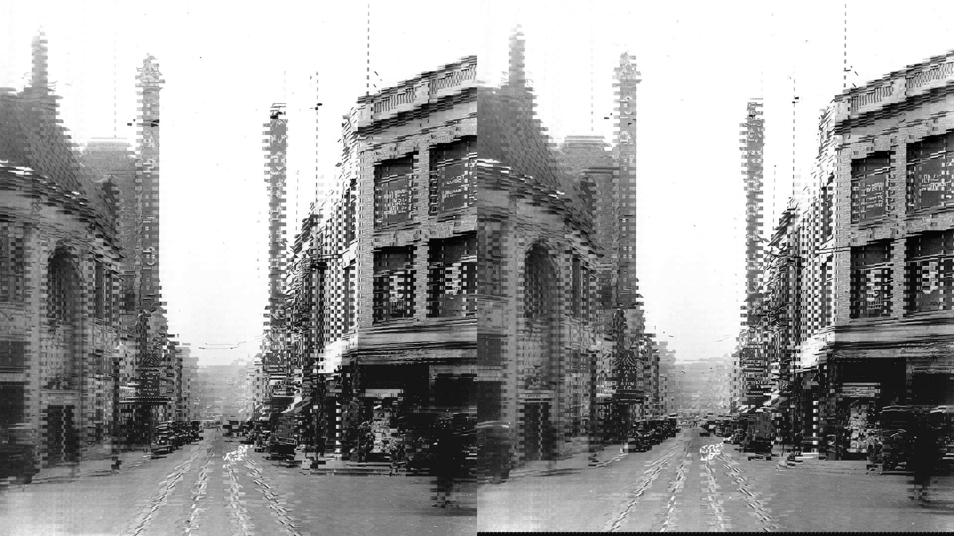 A black and white photo of State Street circa 1928. Two marquees stand vertically on each side of the street. On the left reads 'Capitol' and on the right .New Orpheum'.