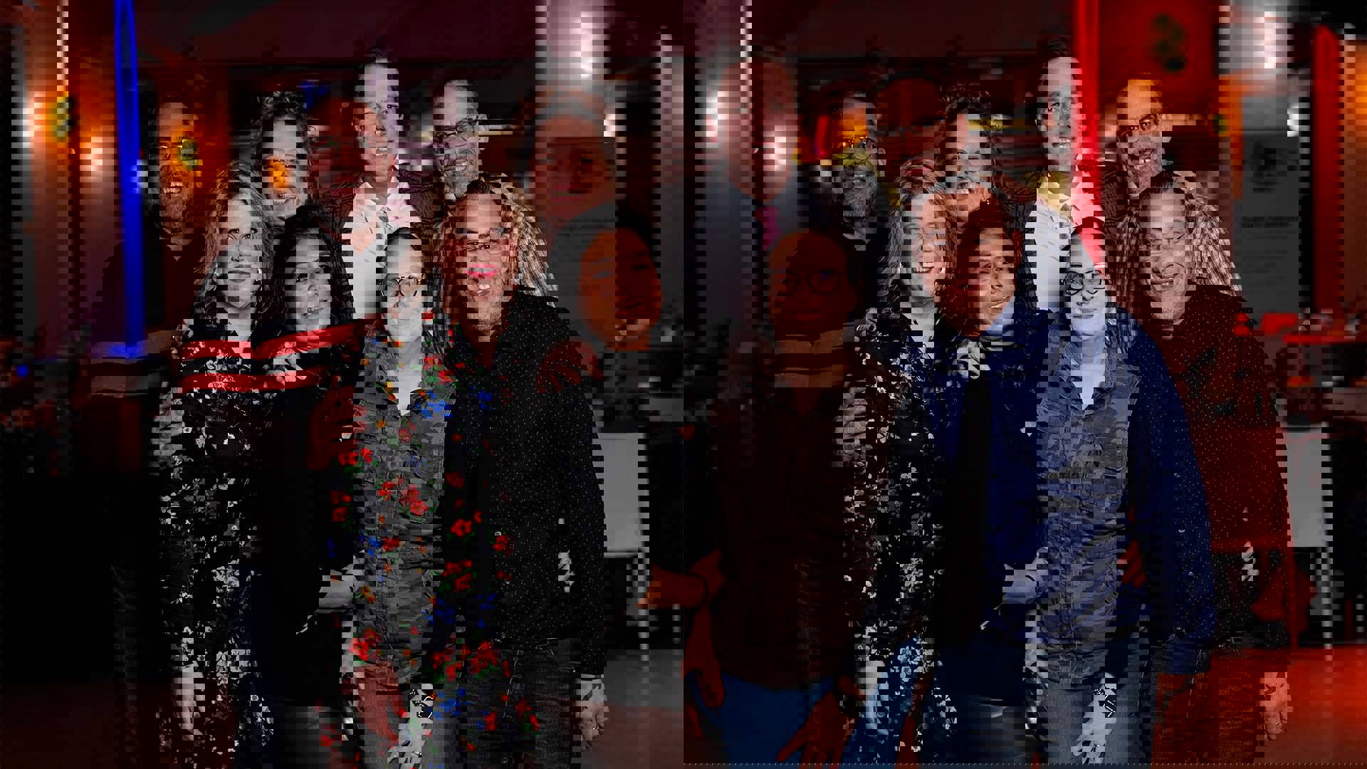 A group of eight people pose for a photo.