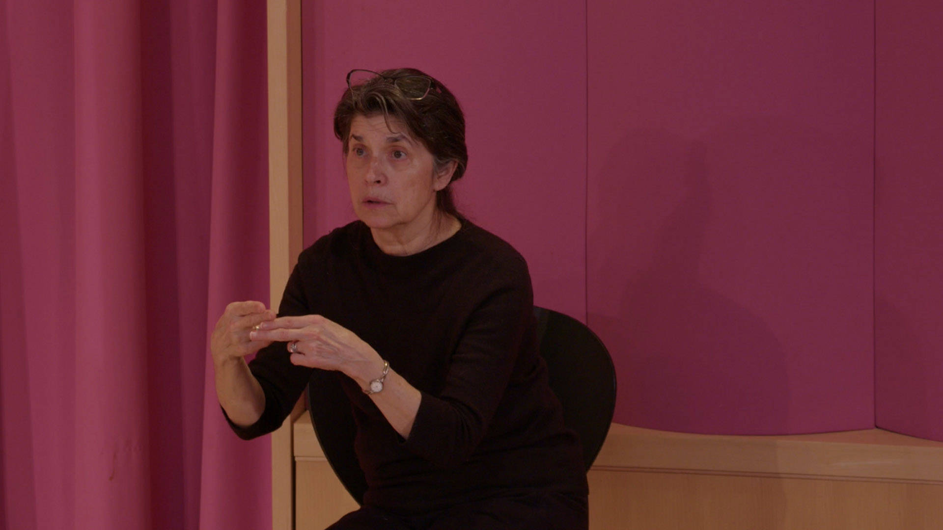 A middle-aged, white woman translating a performance in American Sign Language.
