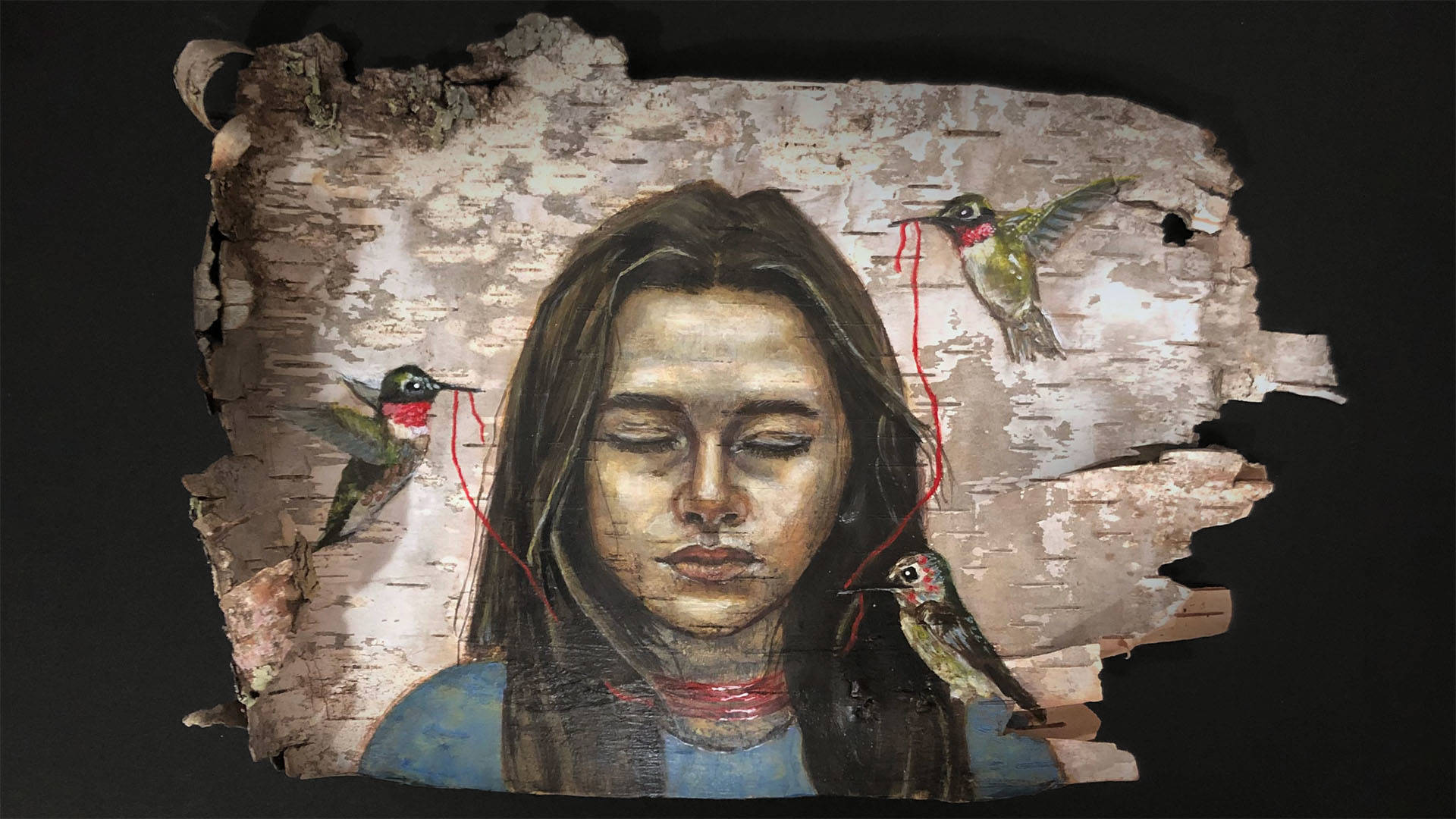 Depiction of a woman with medium complexion, dark hair and closed eyes. Hummingbirds around her hold red string in their beaks.
