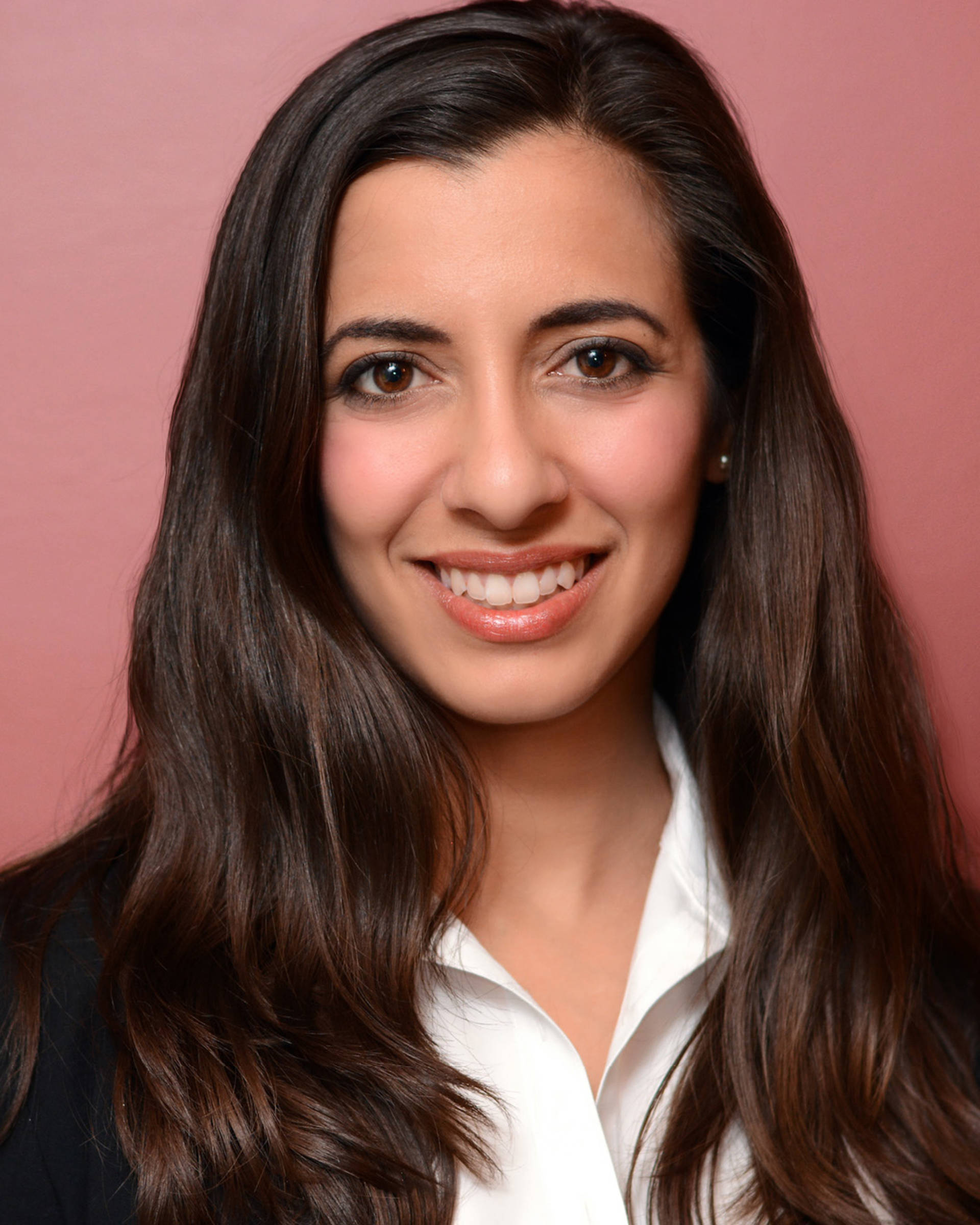 Headshot of a woman with medium complexions, long brown hair, and brown eyes.