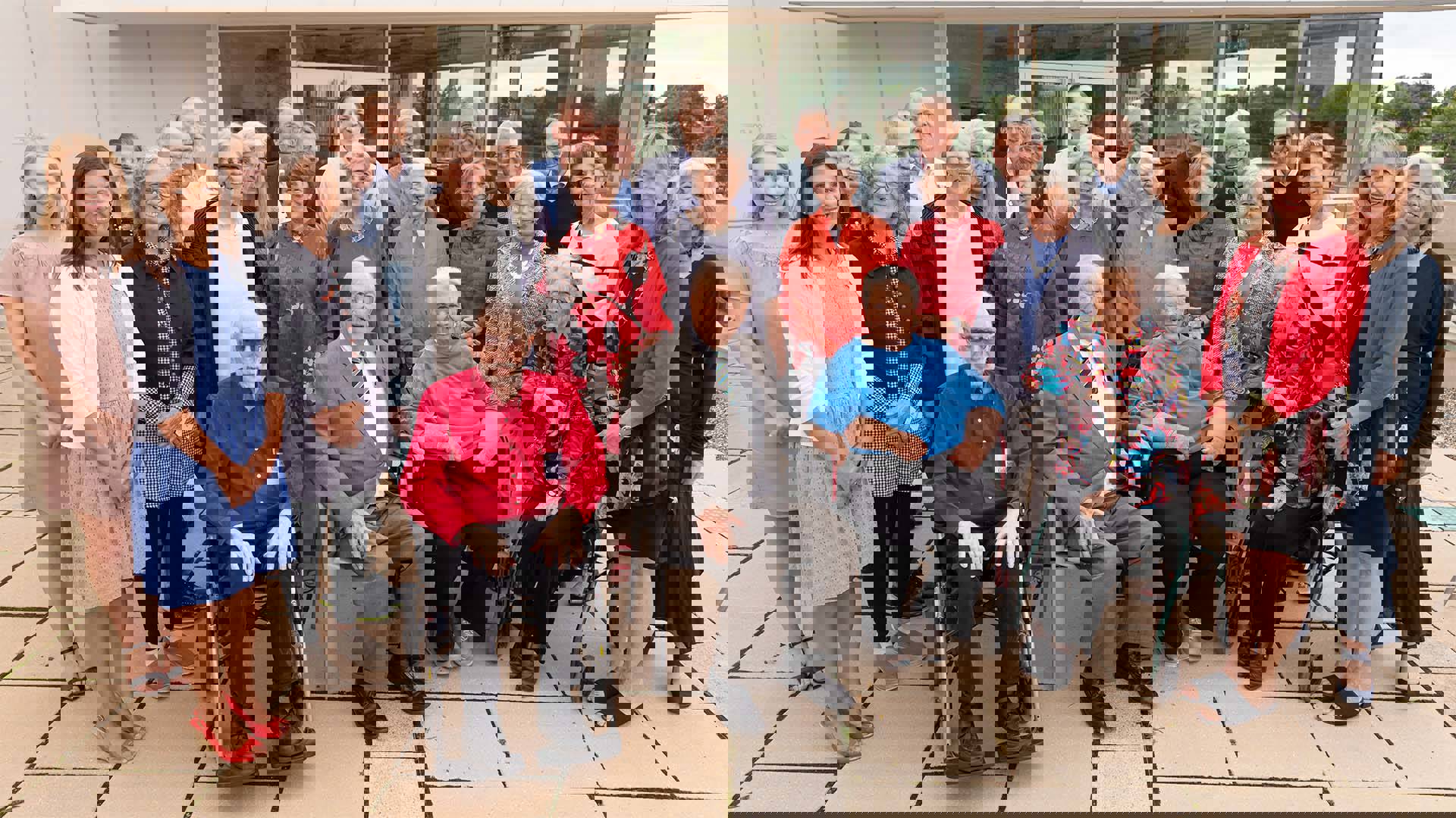 A large group of smiling people standing together for a photo.