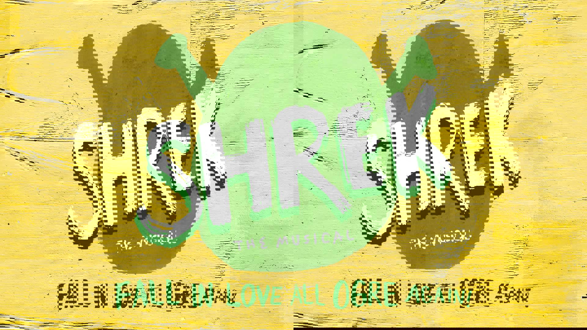 Yellow-painted wooden banner reads: "Shrek the Musical. Fall in love all ogre again!" with a painted green ogre head silhouette behind the large white letters of "Shrek."