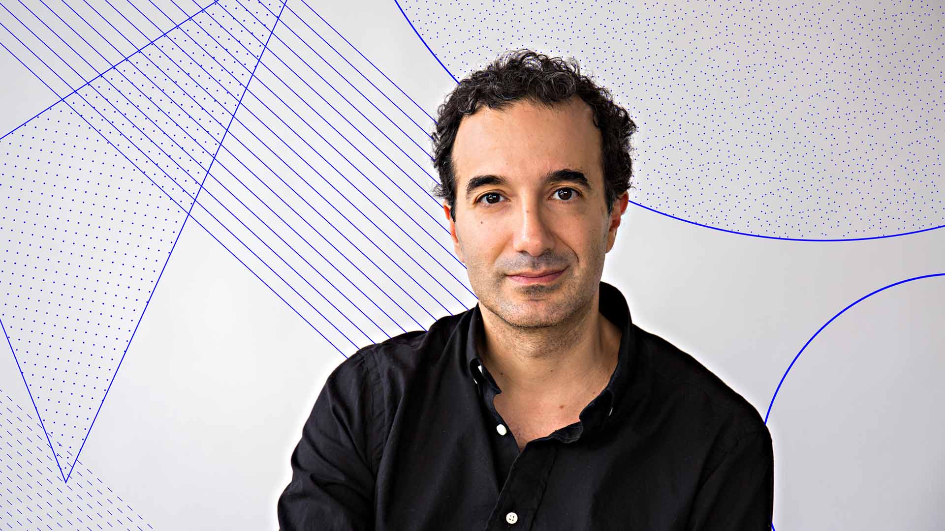 Jad Abumrad Headshot. He has short dark curtly hair and dark eyes. He is wearing a black button up shirt and has a slight smile. Behind Jad is a backdrop of simple blue shapes and lines.