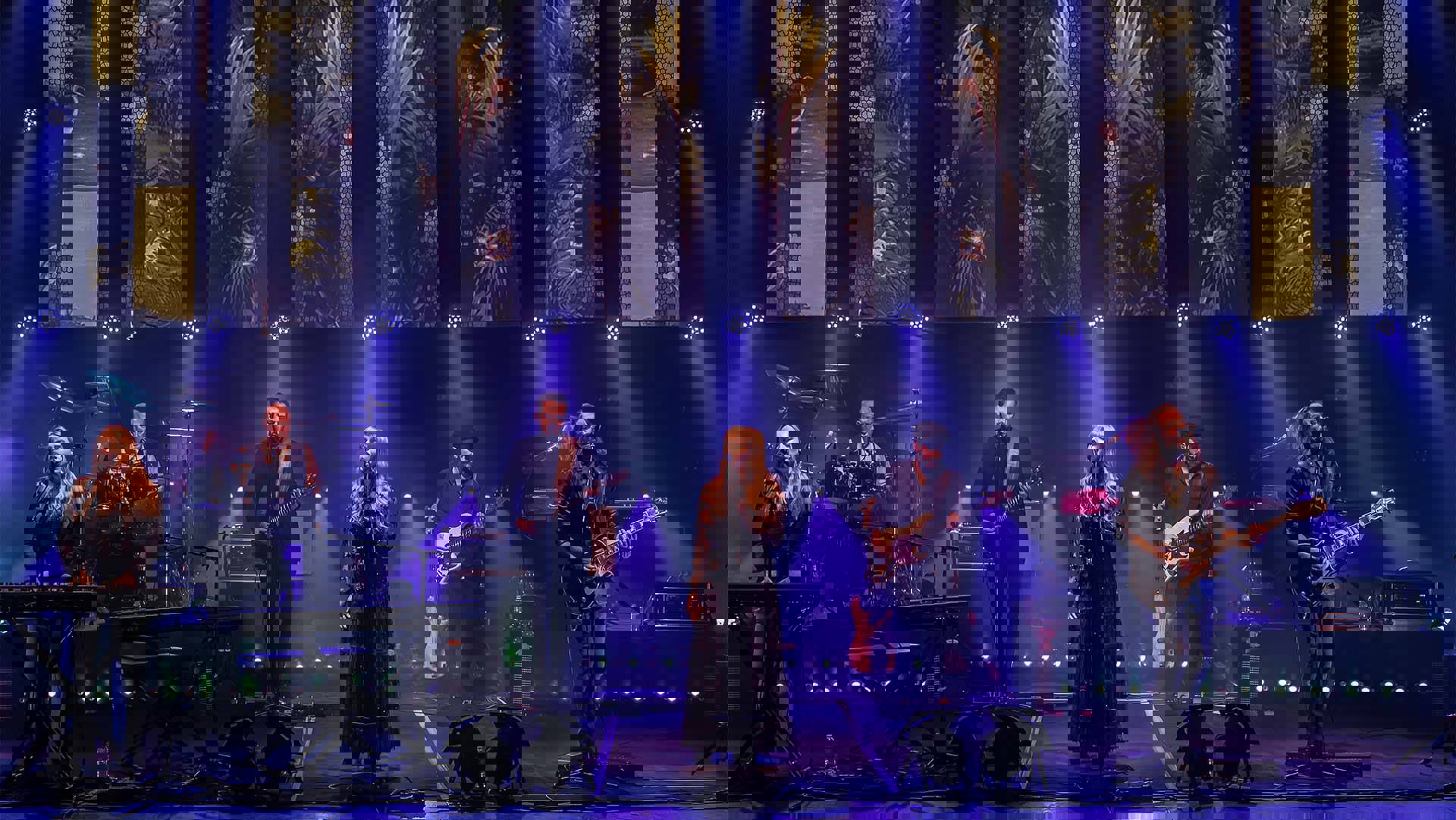 Rumours of Fleetwood Mac band performing on stage with purple stage lighting.