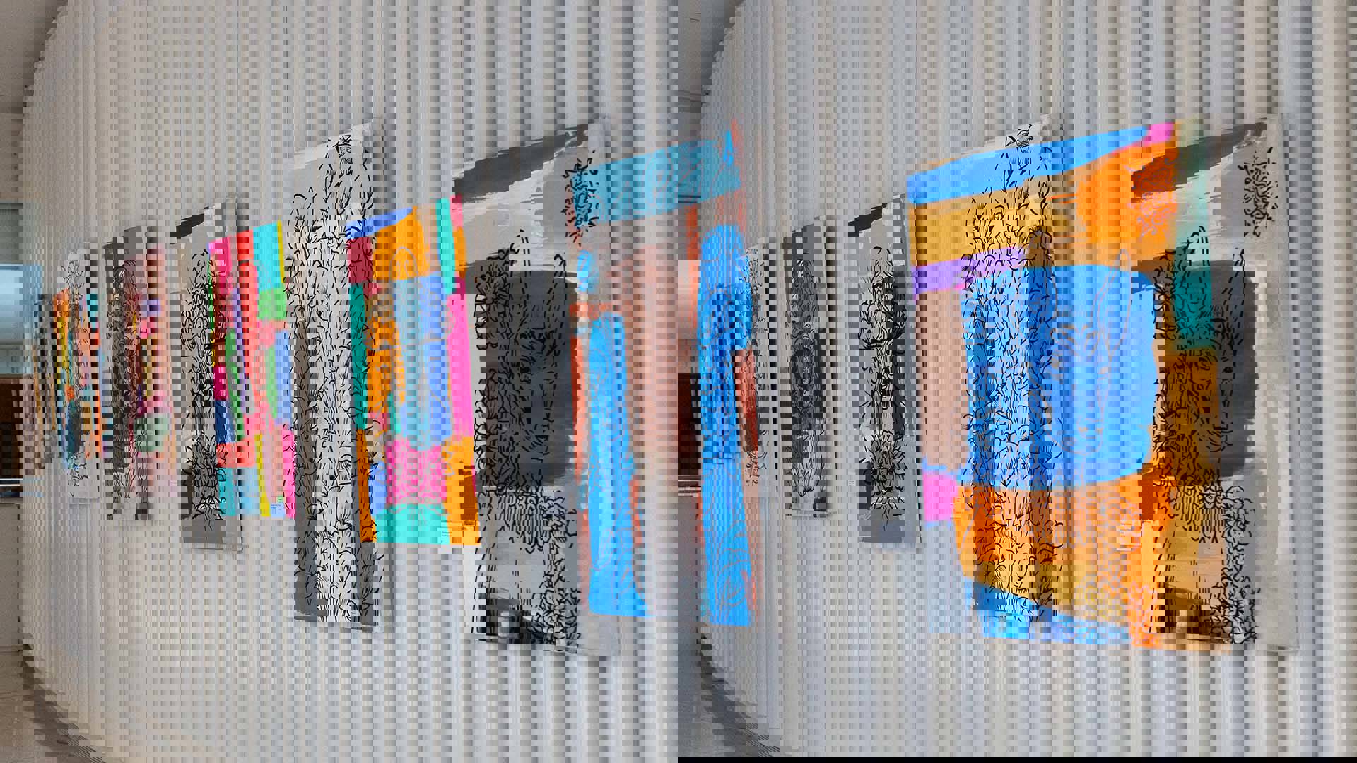 A gallery wall full of colorful paintings.