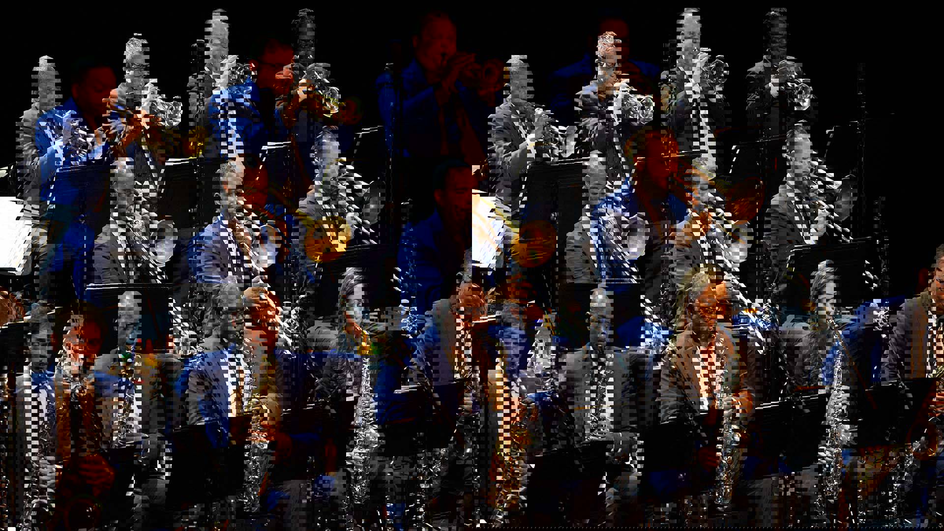 Close up of a jazz big band horn section performing on a stage.