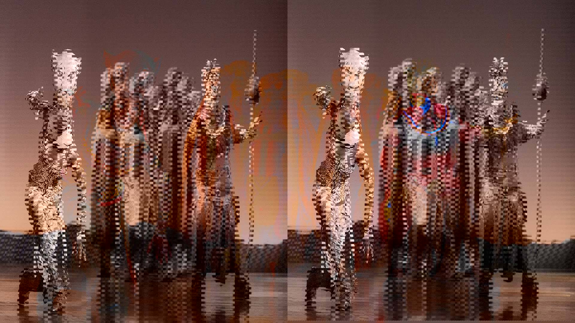 Actors dress as Lionesses and Rafiki strike a variety of poses on stage