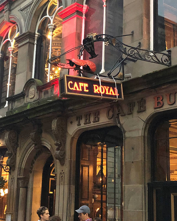 A theater front with a marque that reads Cafe Royal.